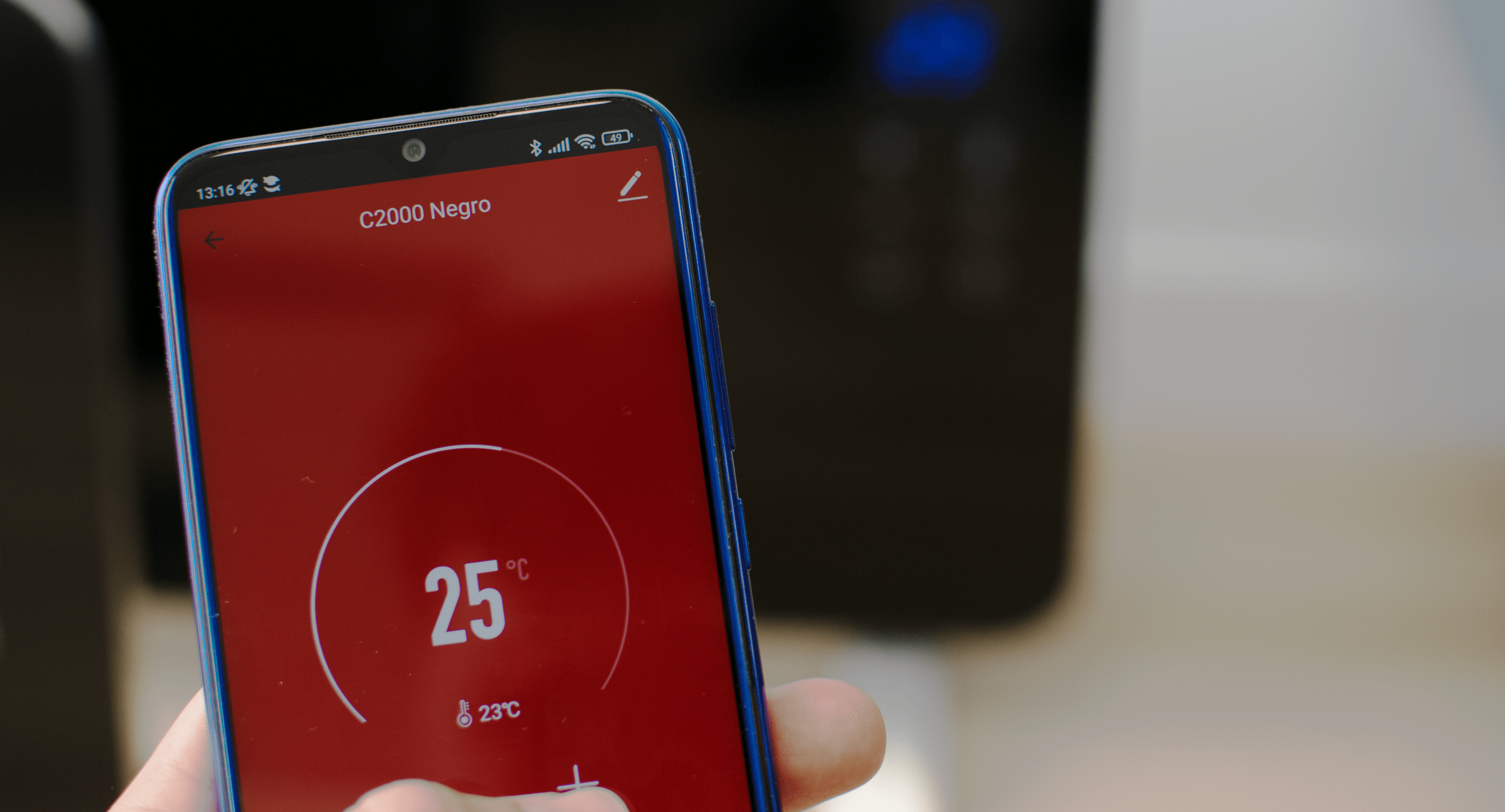 Una pantalla de smartphone mostrando una interfaz roja con una lectura de temperatura.