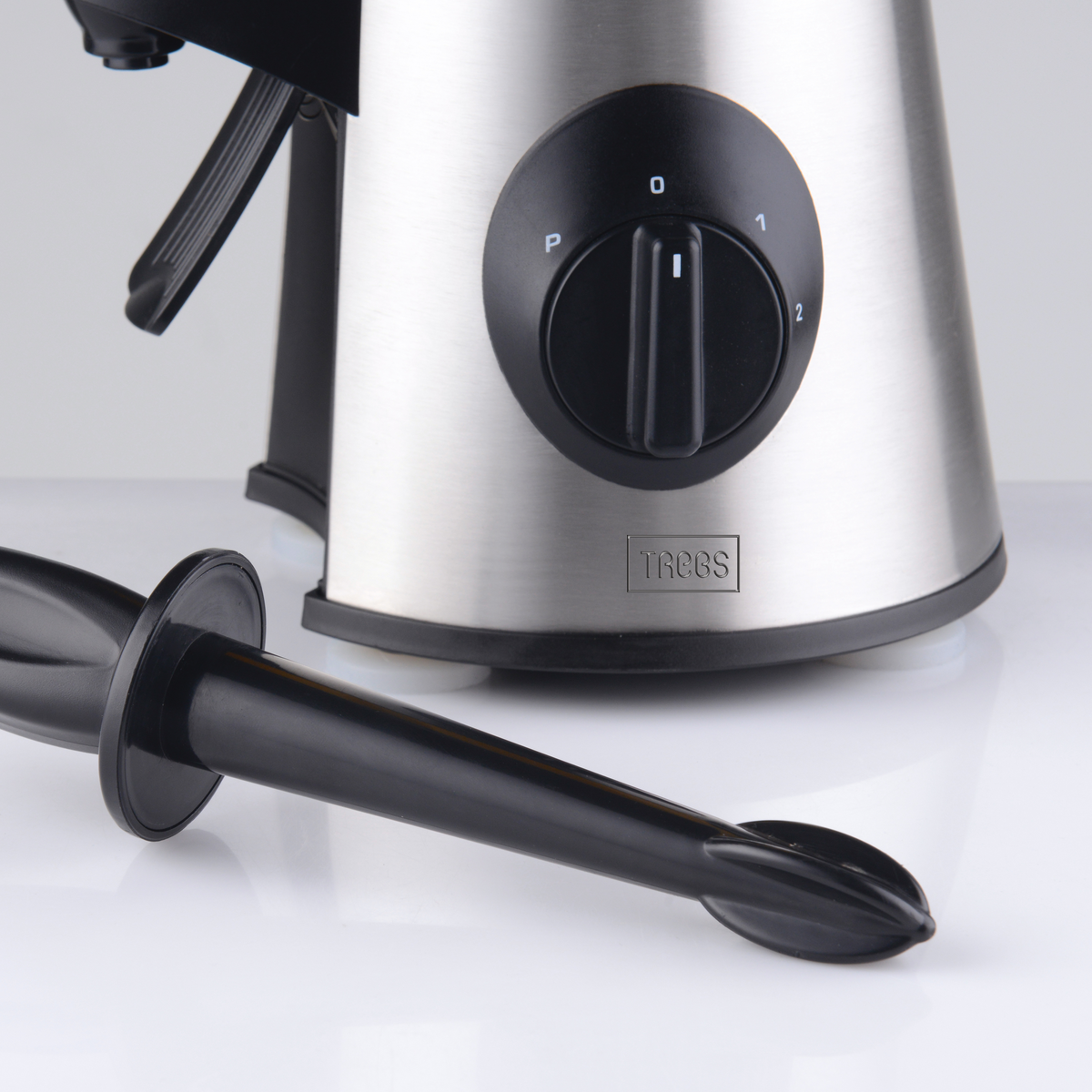 Close-up van een blender met zwarte bedieningsknop. De blender is van roestvrij staal.