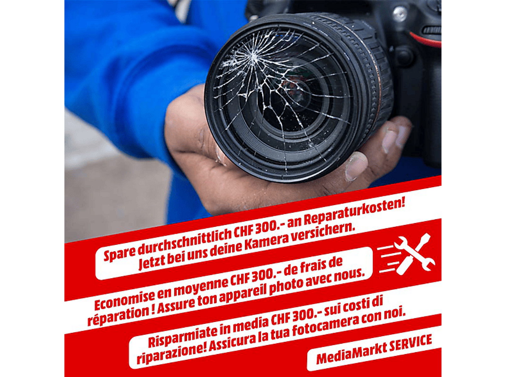 Uszkodzony obiektyw aparatu trzymany przez osobę, z tekstem o kosztach naprawy.