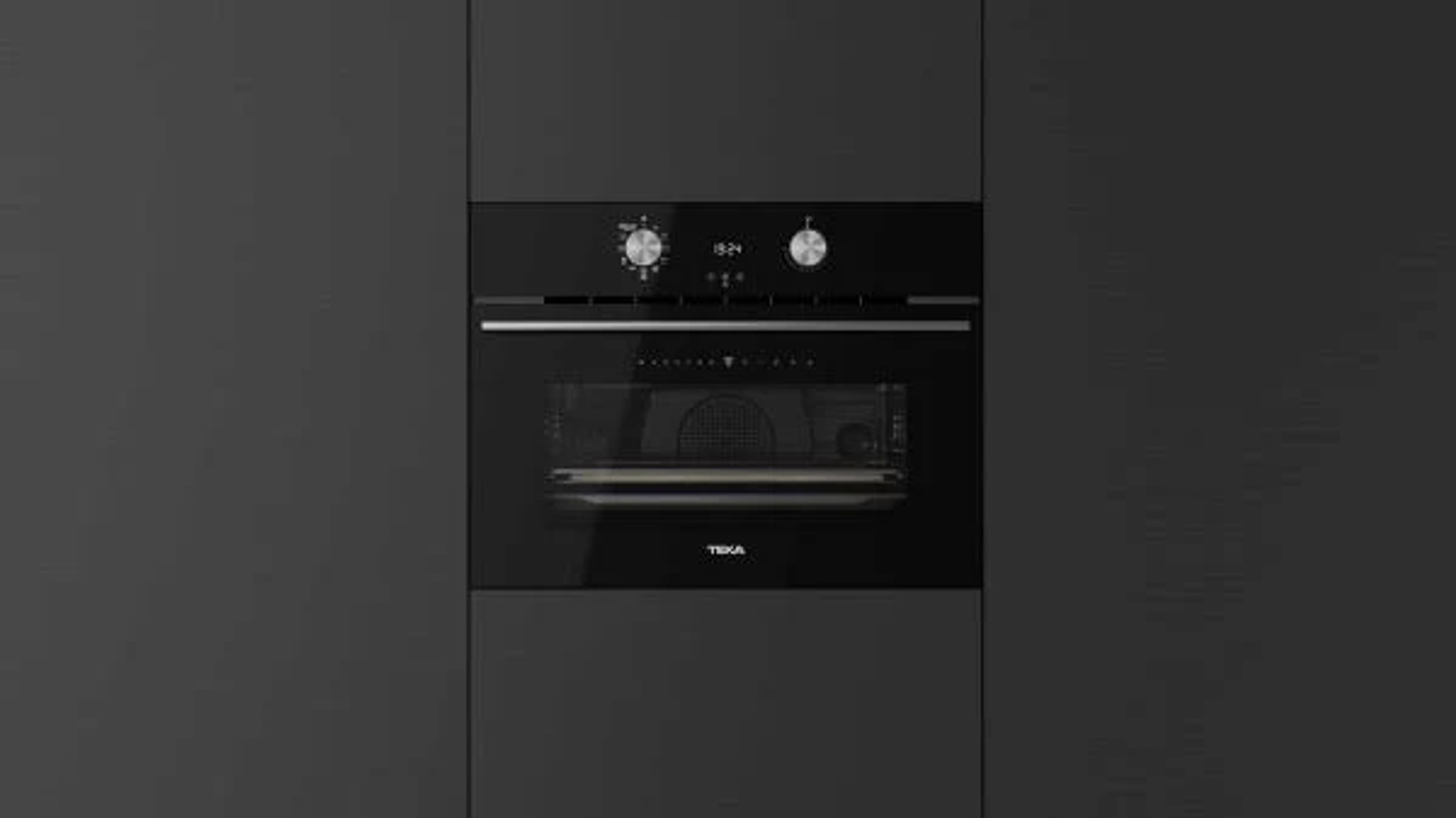 Horno negro empotrado en una pared gris oscura. Dos diales y una pantalla sobre la puerta. Logotipo de TEKA.