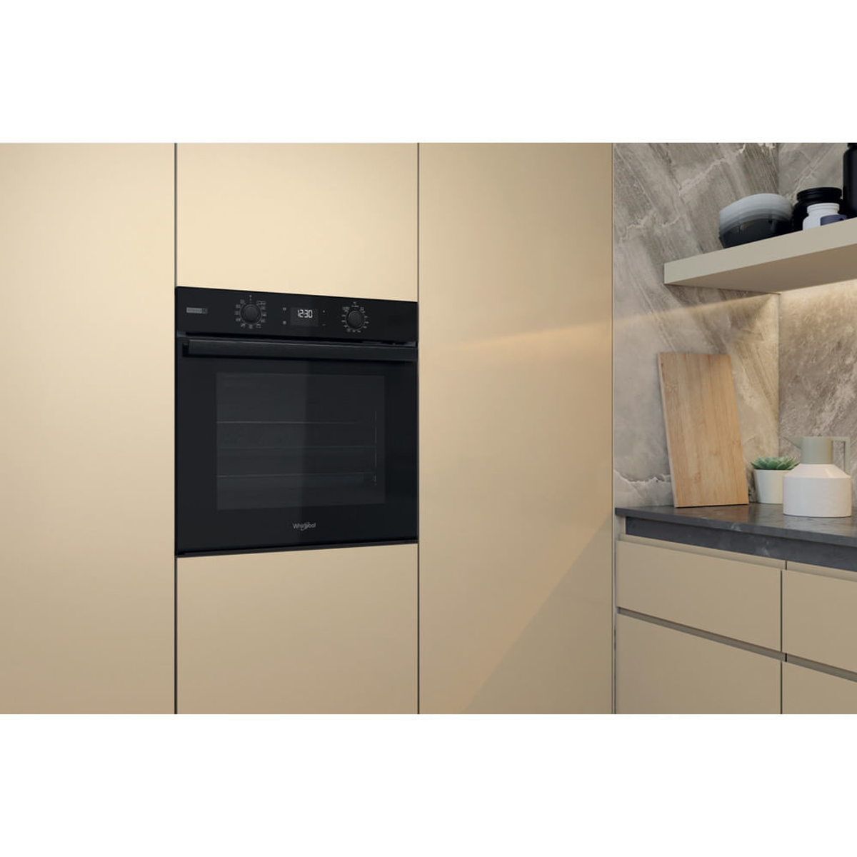 Forno Whirlpool nero incassato in mobili beige, con porta in vetro scuro e pannello di controllo.