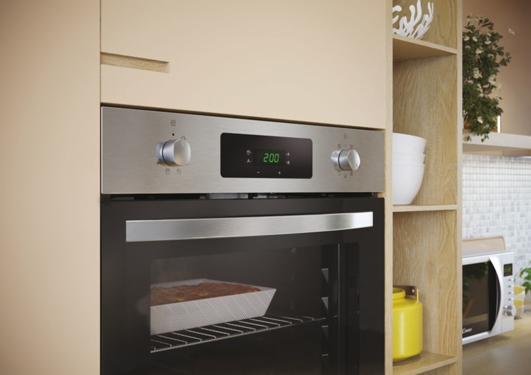 Horno con pantalla digital, frontal de acero inoxidable y plato dentro. Armario beige lo rodea.