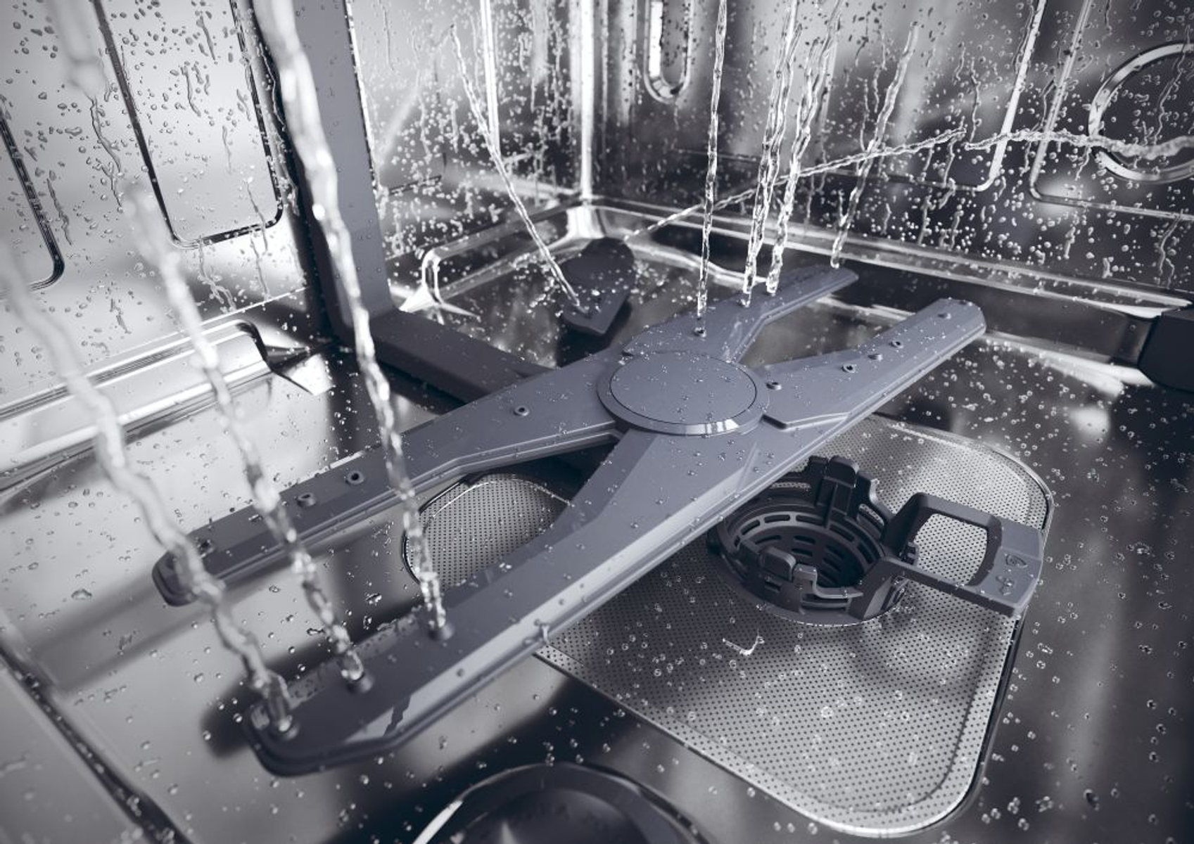 All'interno di una lavastoviglie con acqua che spruzza sui bracci di spruzzo grigi e sul fondo.