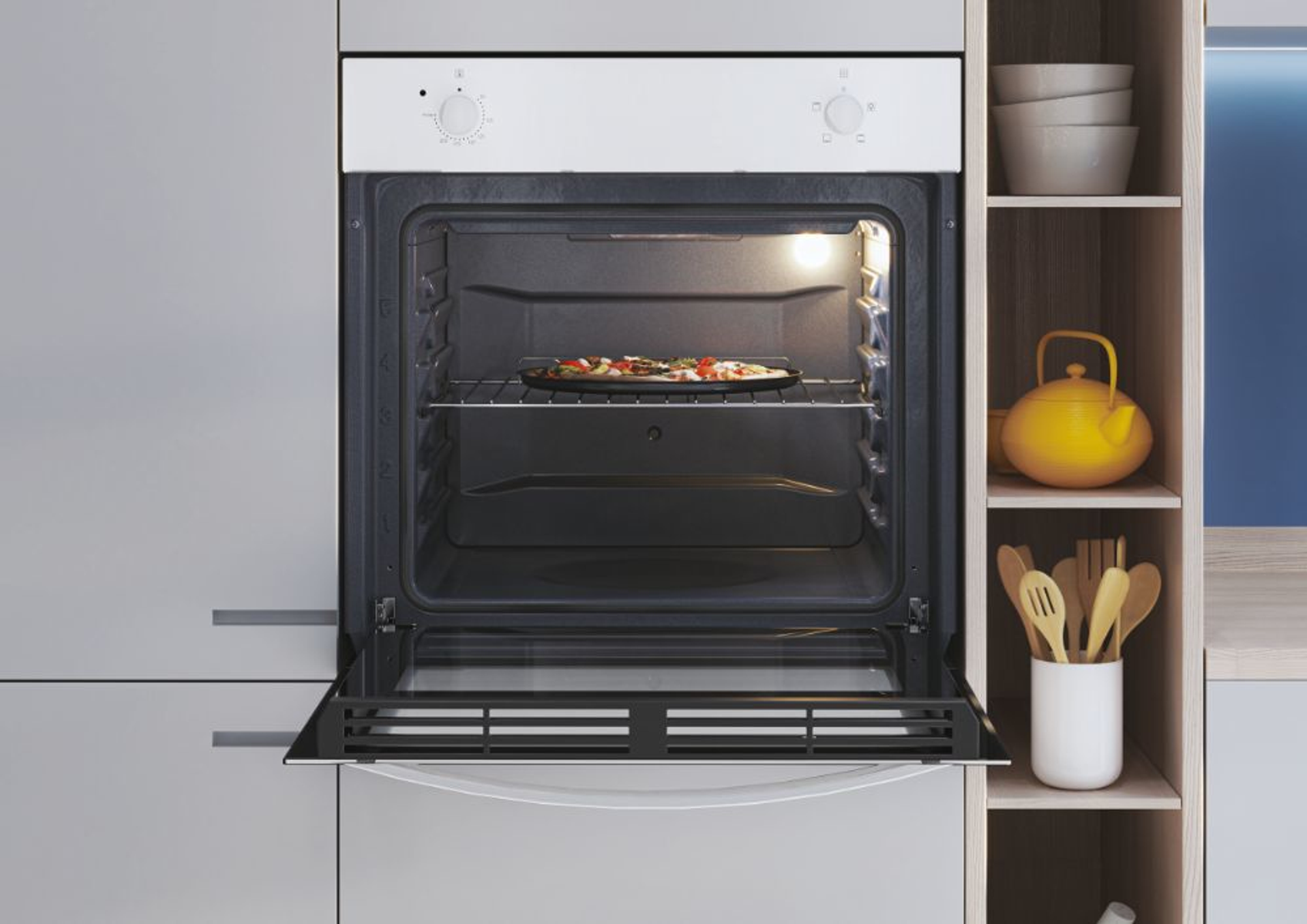 Un forno con la porta aperta, che mostra una pizza su una griglia. Mensole con ciotole, una teiera e utensili a destra.