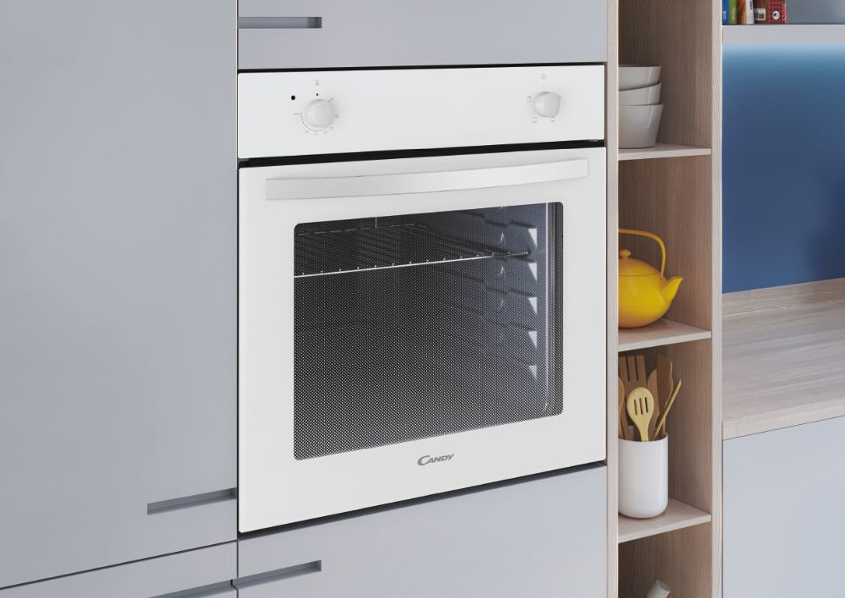 Forno Candy bianco integrato in un mobile da cucina grigio con un ripiano contenente una teiera gialla.