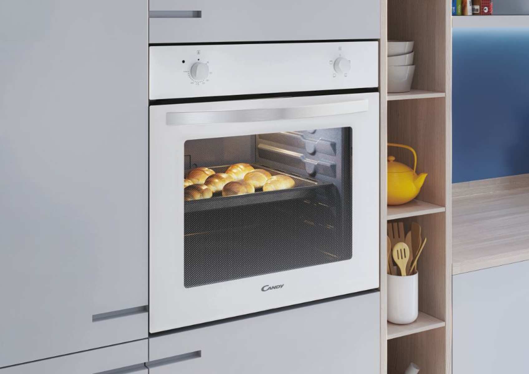 Un forno integrato in un mobile da cucina, con una teglia di pane cotto all'interno.