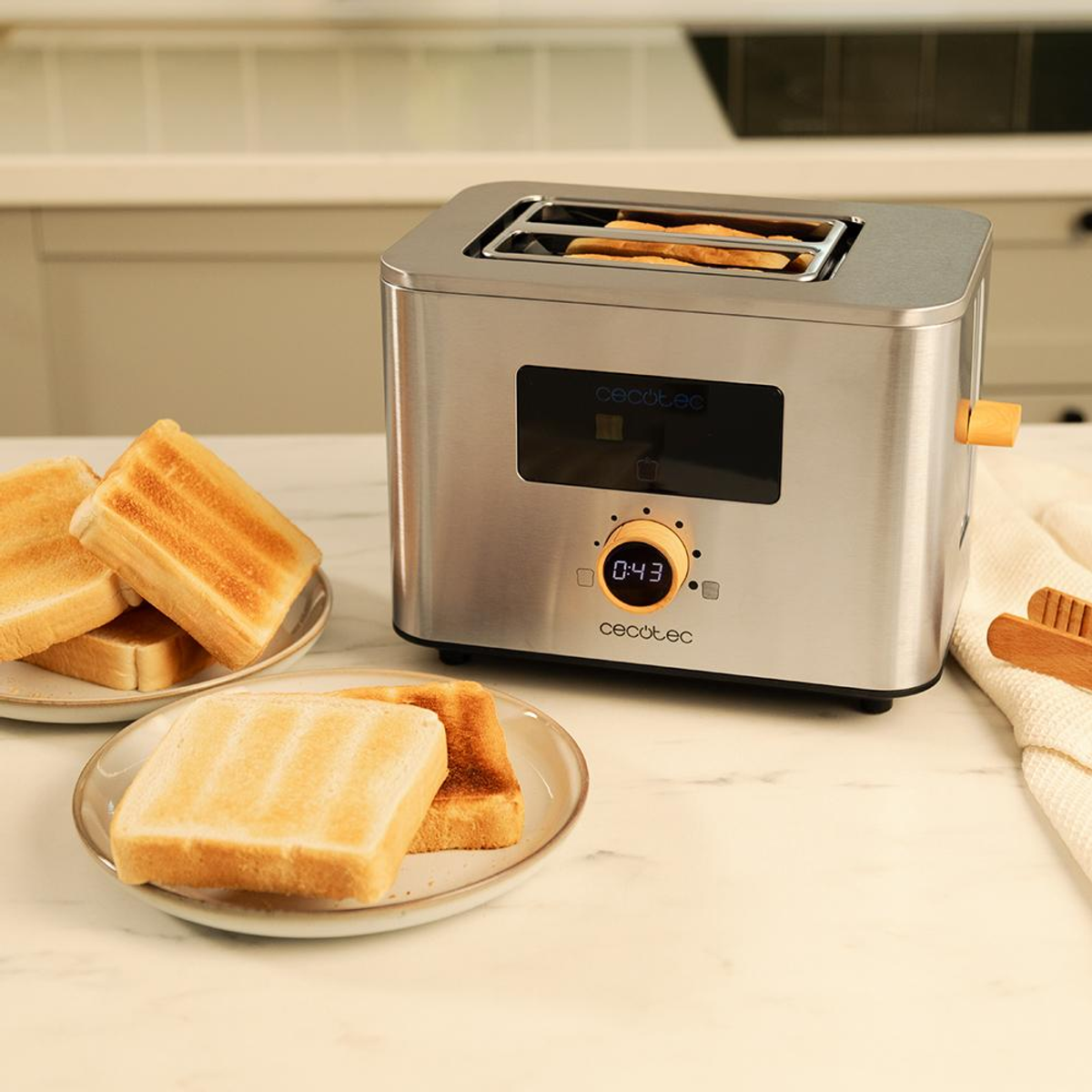 Un tostapane argentato con toast e piatti su un bancone della cucina.