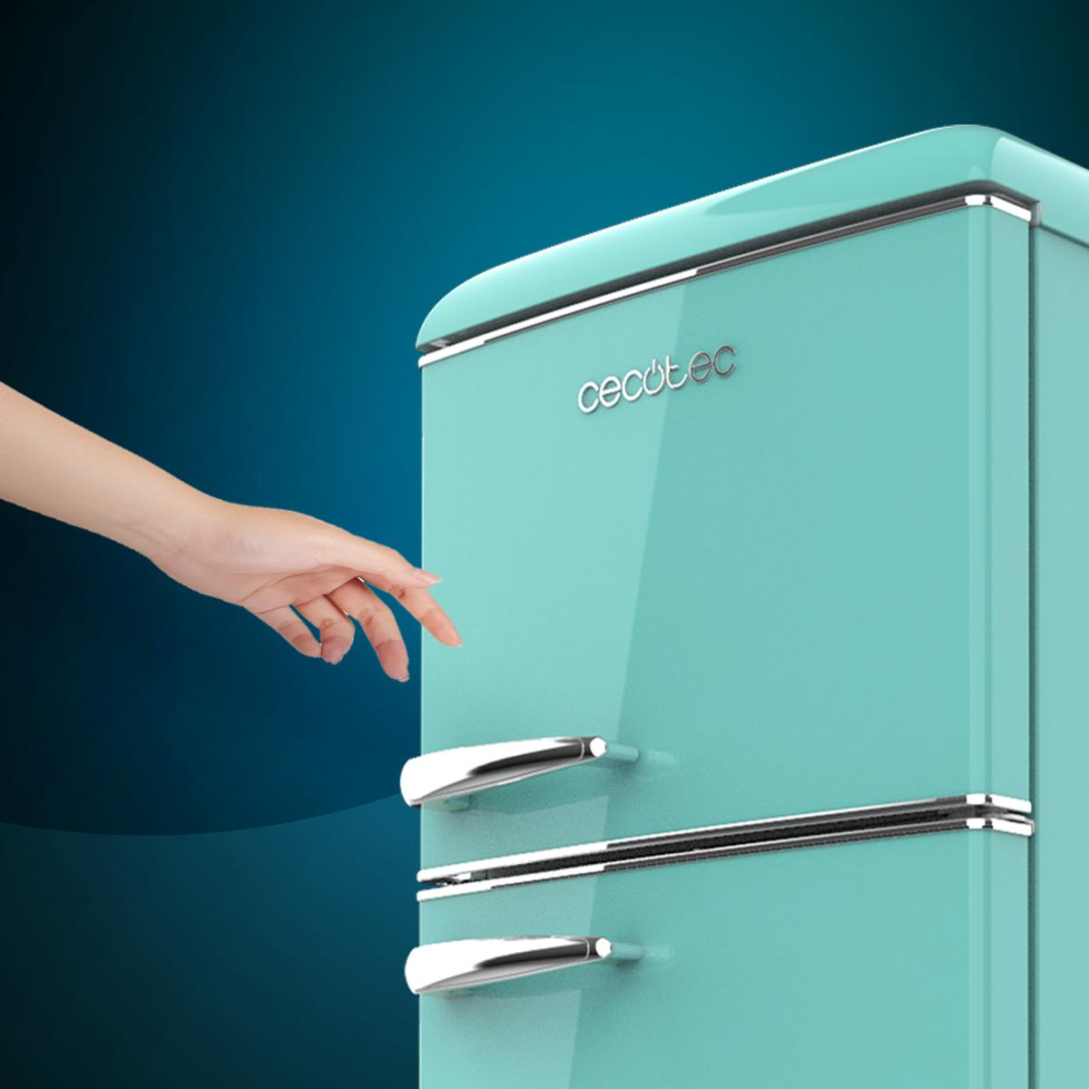 Un refrigerador retro turquesa con manijas cromadas, y una mano que se acerca a él.