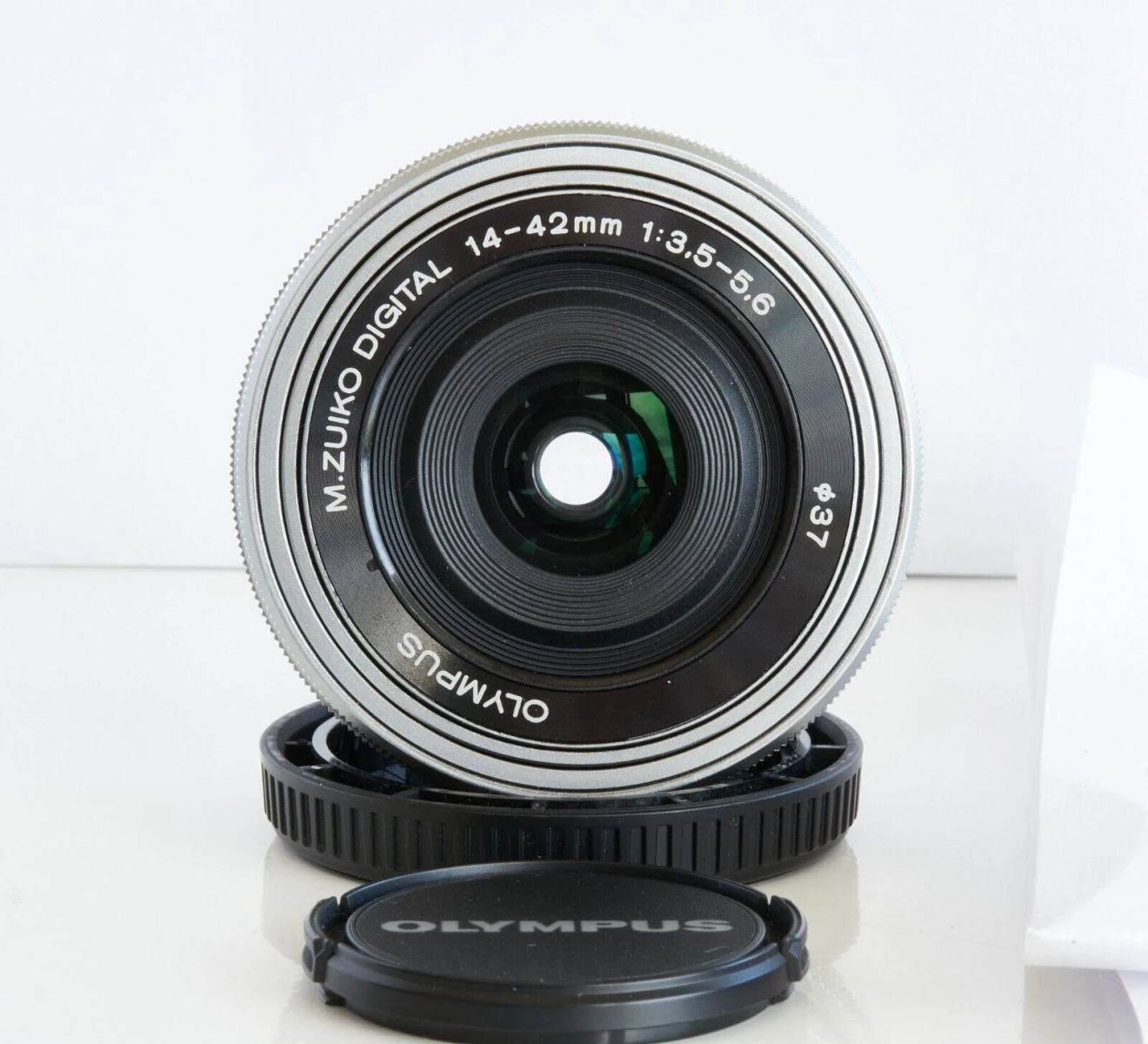 Een close-up van een cameralens met tekst. De lens is zwart en zilver met een lensdop.