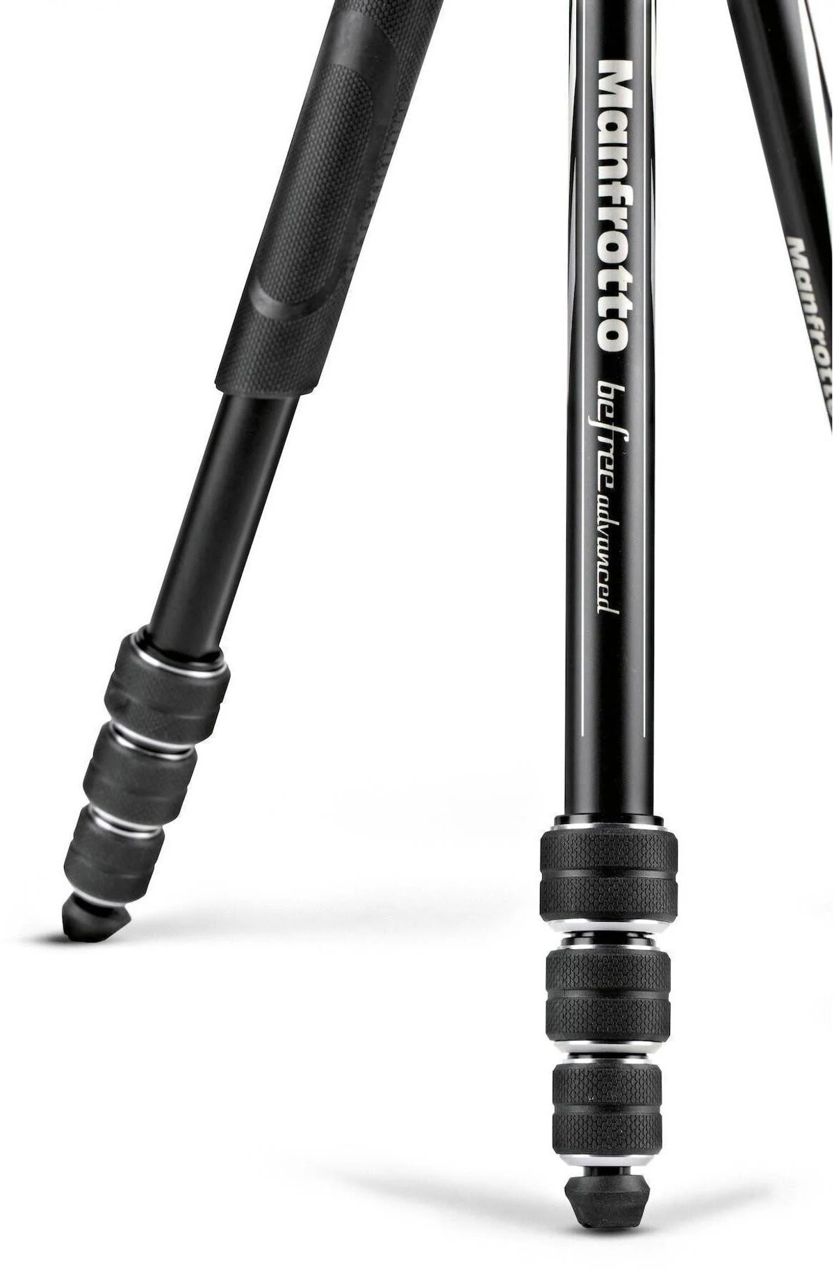 Primer plano de las patas de un trípode, negras con marca Manfrotto y pies de goma.