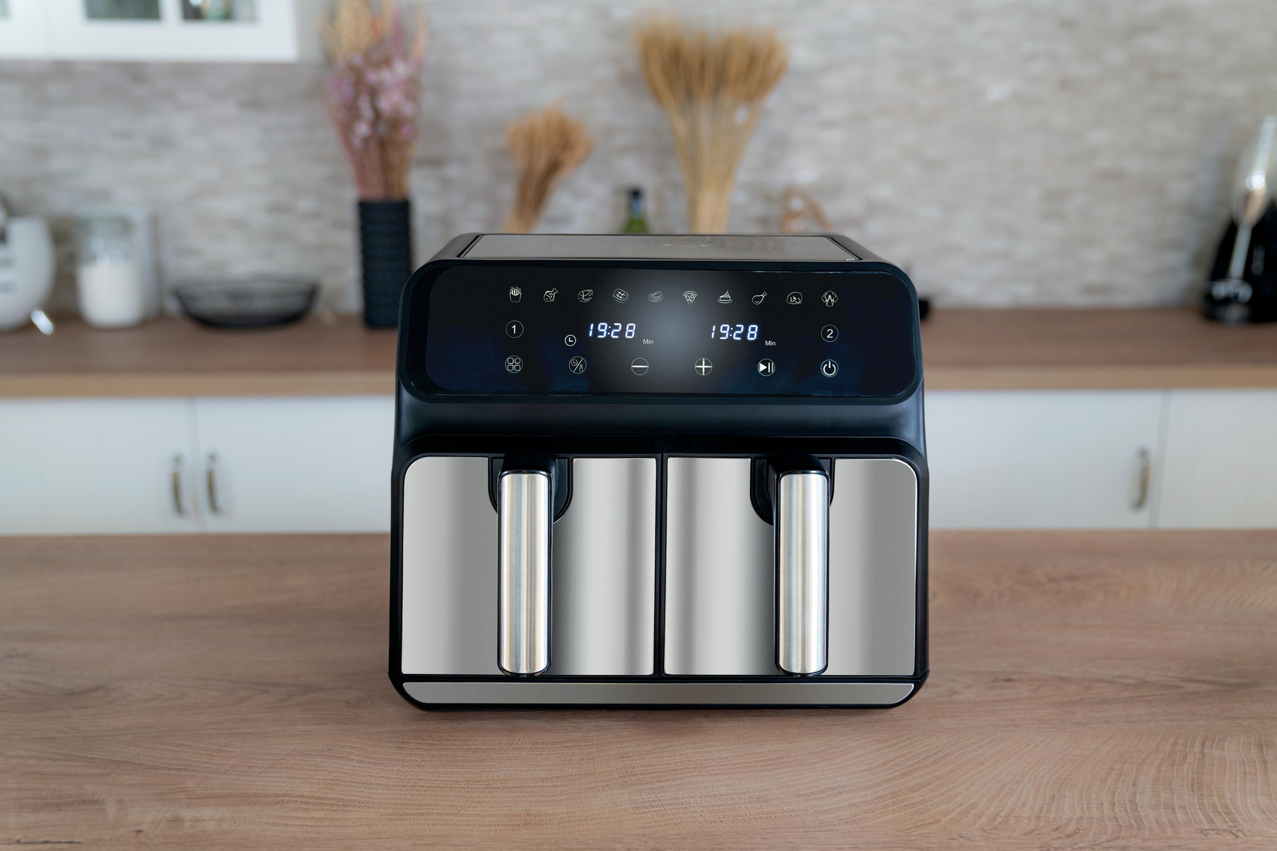 Czarna i srebrna frytkownica na drewnianym stole.