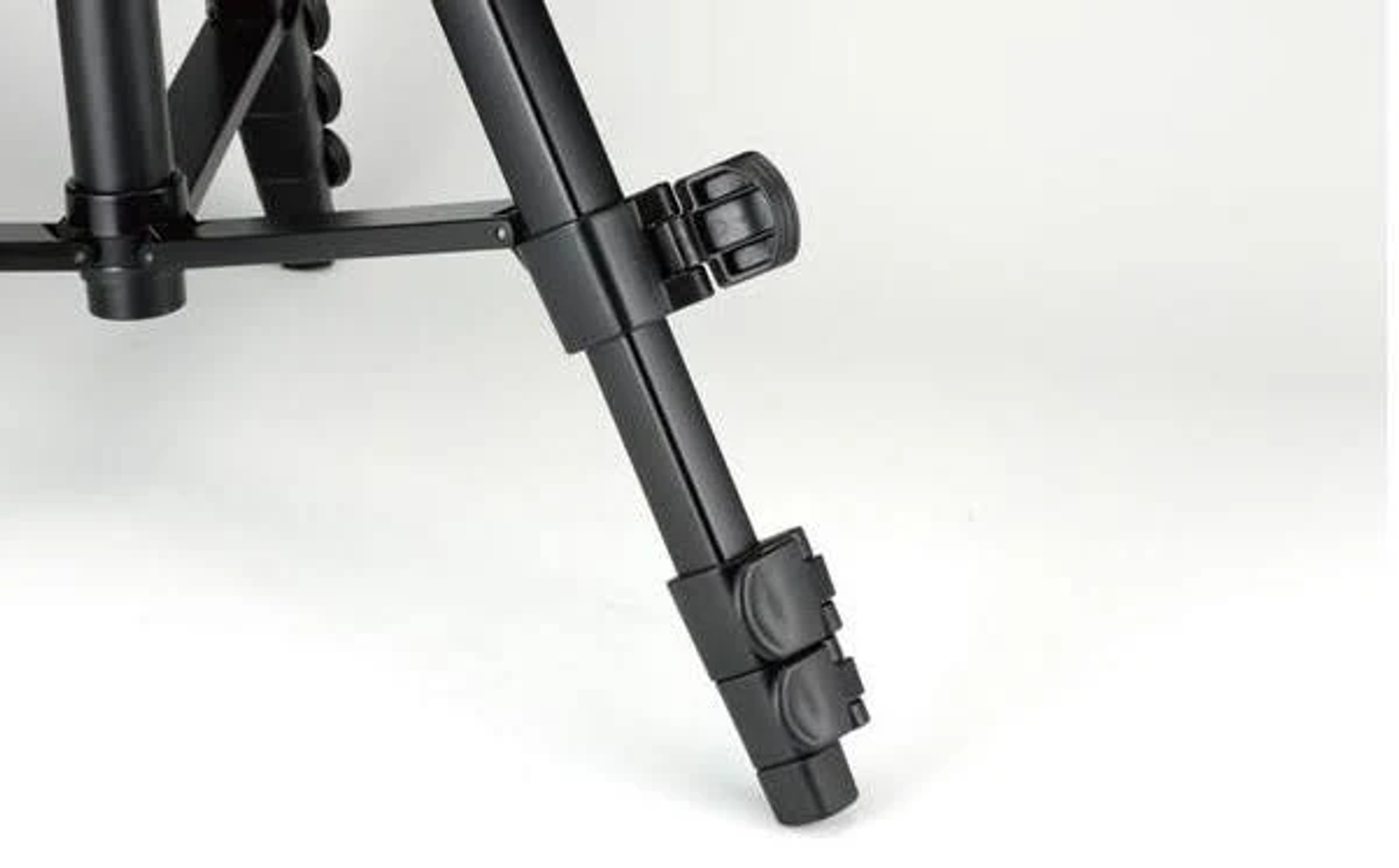 Close up of a black tripod leg with adjustable locking mechanisms.