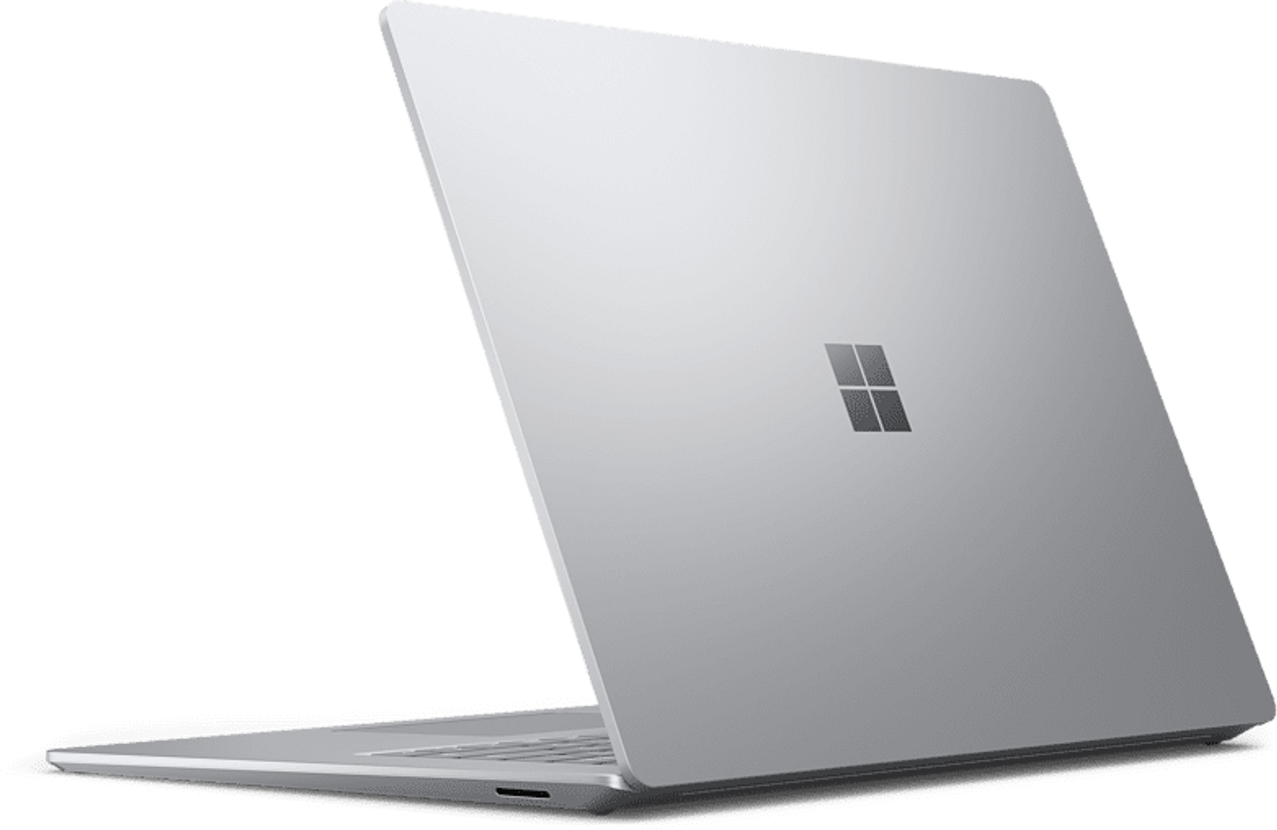 Portátil plateado con logo Microsoft abierto sobre fondo negro.