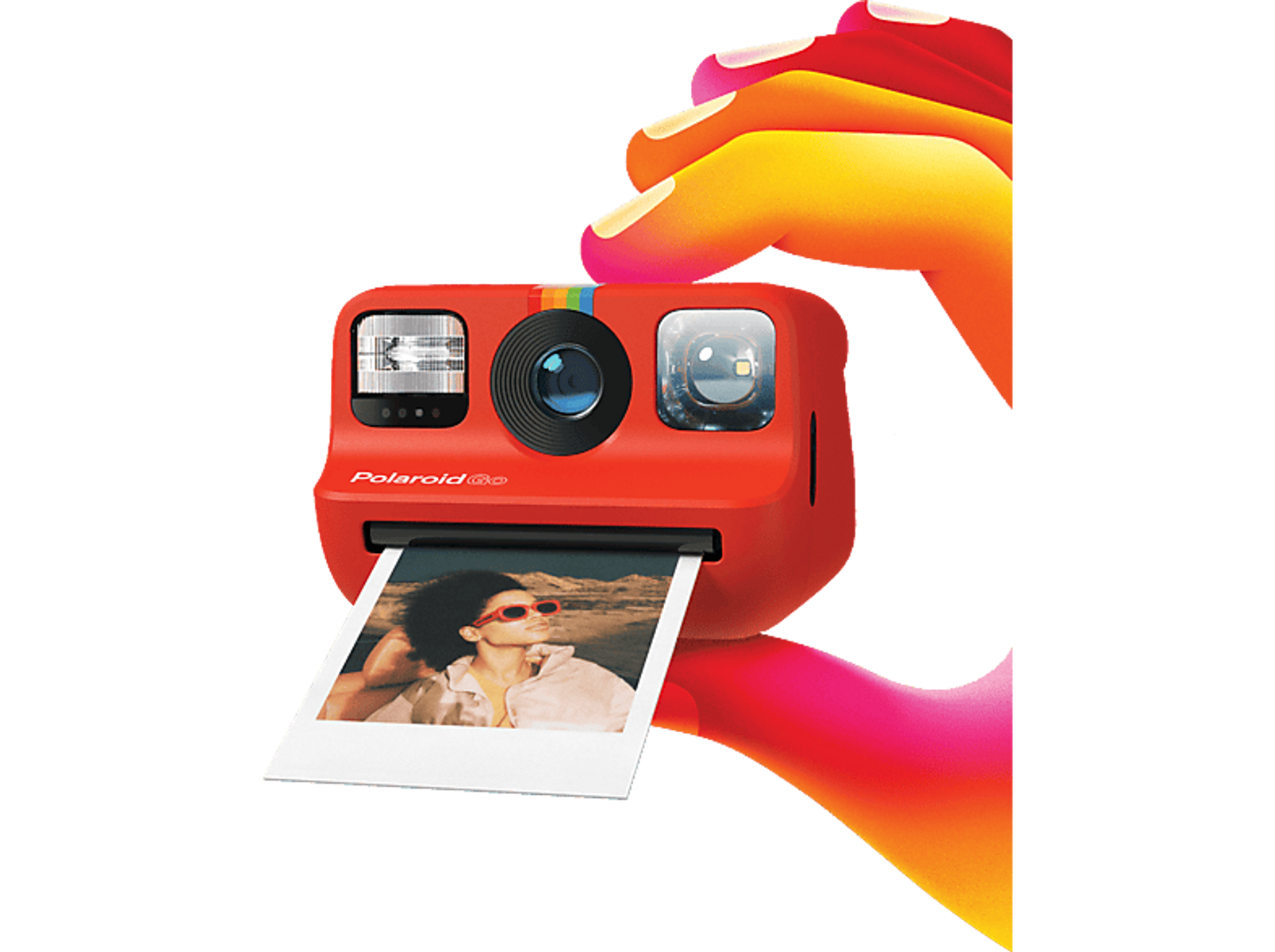 Una cámara Polaroid Go roja sostenida por una mano, con una foto imprimiéndose.