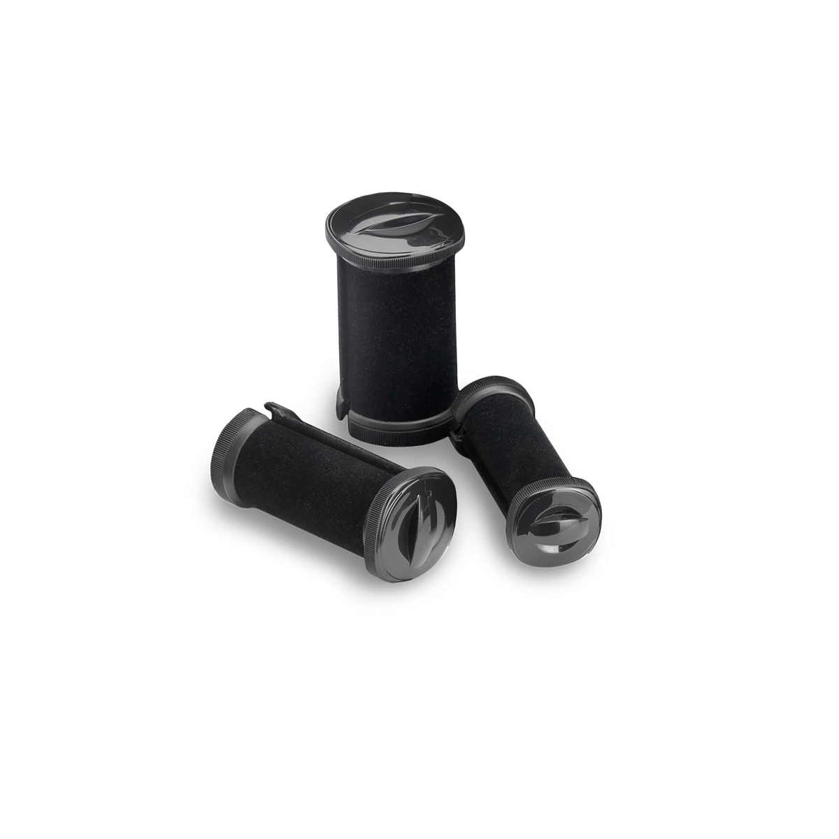 Trzy czarne wałki do włosów na białej powierzchni. Mają zaokrąglony kształt.