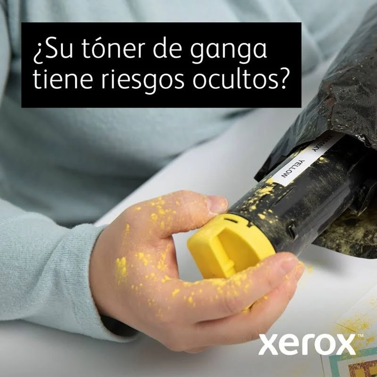 Ręka trzyma żółty wkład z tonerem. Widoczny jest żółty proszek z tonera.