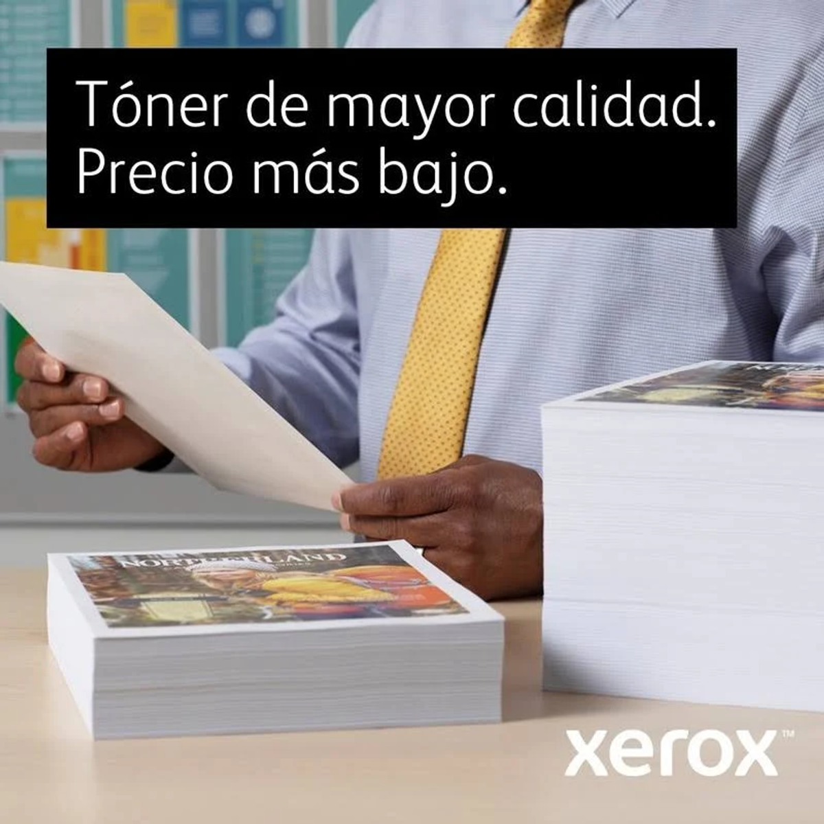 Mężczyzna trzyma stos papieru z logo Xerox i tekstem o jakości i cenie.