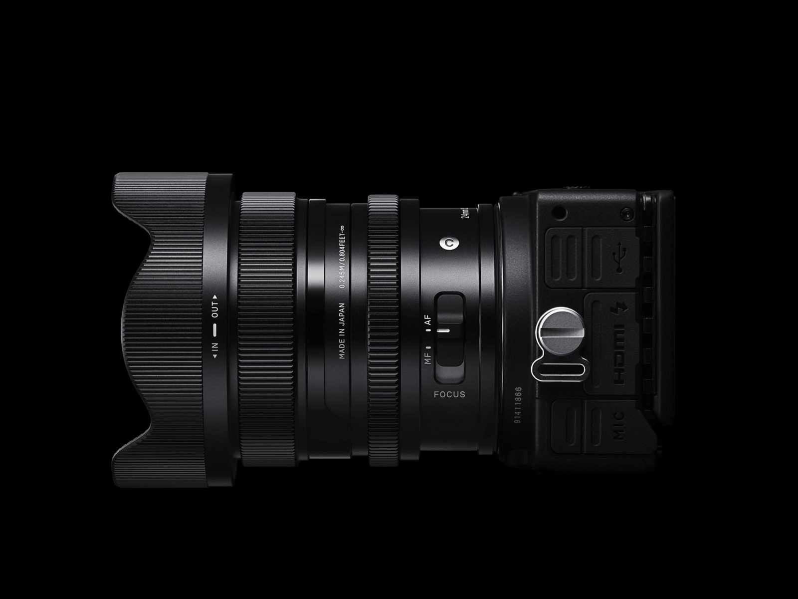 Czarny obiektyw z osłoną przeciwsłoneczną przymocowany do korpusu aparatu, na czarnym tle.