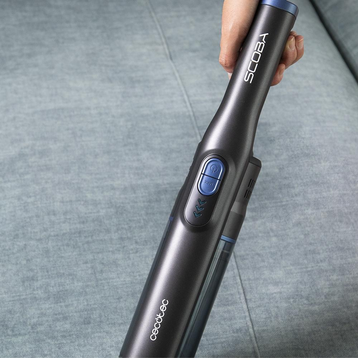 Mano che tiene un aspirapolvere Cecotec Scooba grigio scuro. Pulsante e un contenitore trasparente.