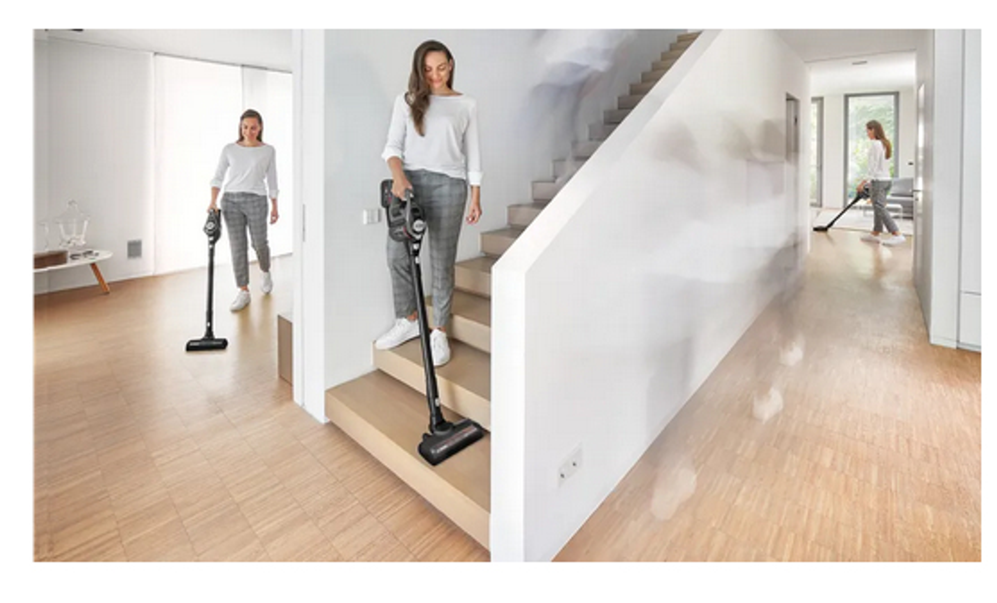 Eine Frau saugt ein Haus mit einem schwarzen, kabellosen Staubsauger. Die Szene zeigt Treppen und einen Holzboden.
