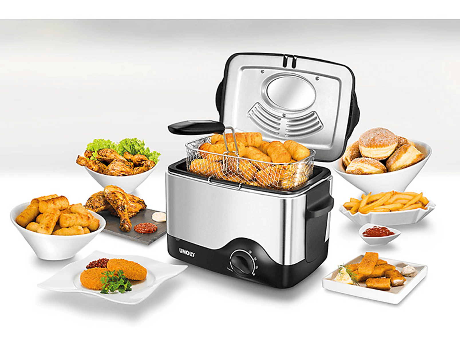 Frytownica z jedzeniem i różnymi dodatkami. Tło to ustawienie studyjne.