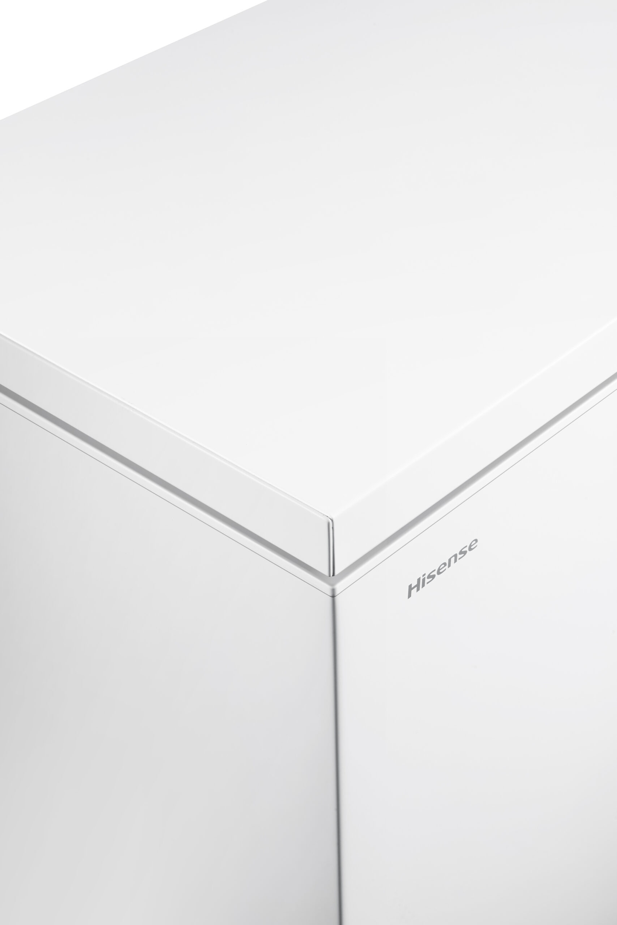 Una vista ravvicinata di un congelatore orizzontale bianco, che mostra un angolo e il logo 'Hisense'.