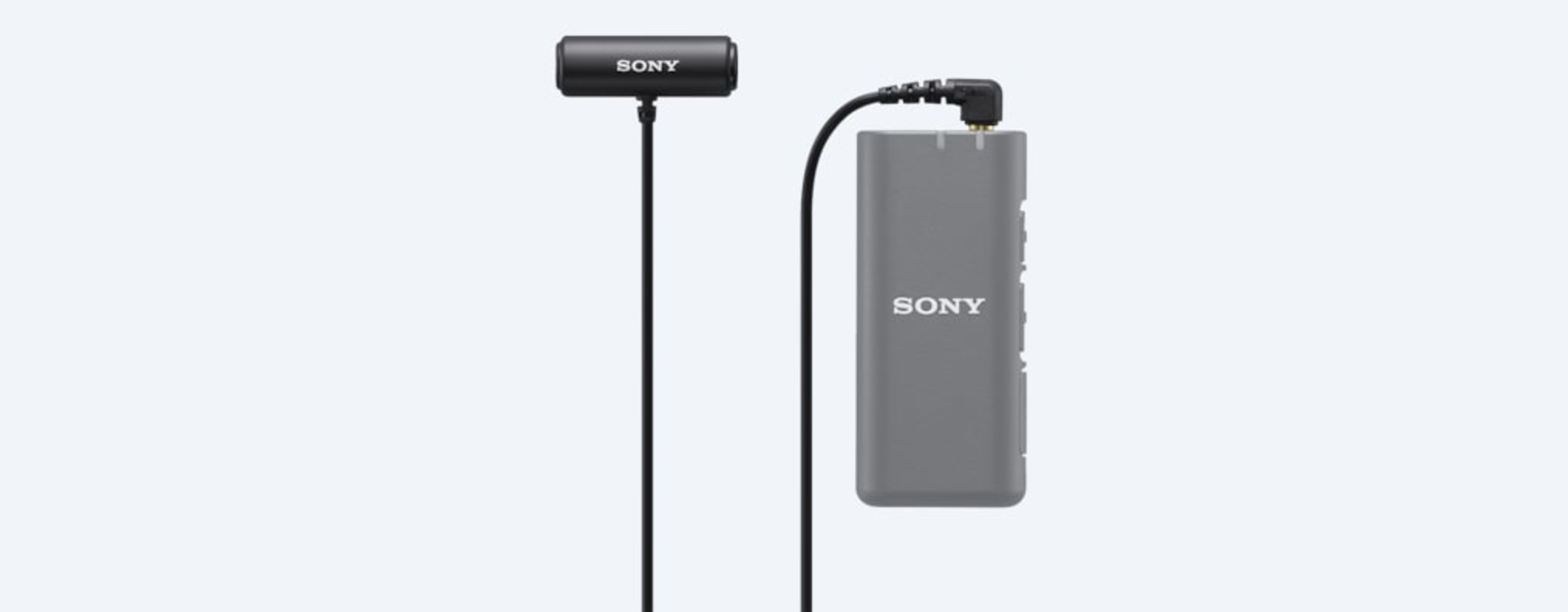 Ein schwarzes Mikrofon, das mit einem grauen rechteckigen Gerät mit dem Wort SONY darauf verbunden ist, mit hellem Hintergrund.