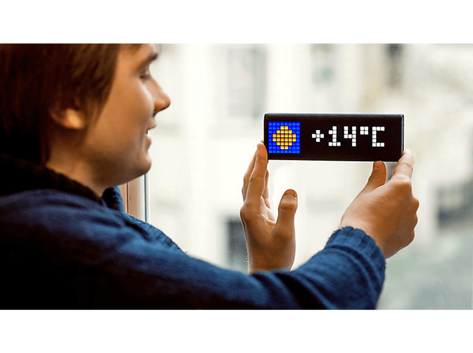 Un homme tenant un affichage de température avec une icône bleue et jaune. Fond de fenêtre.