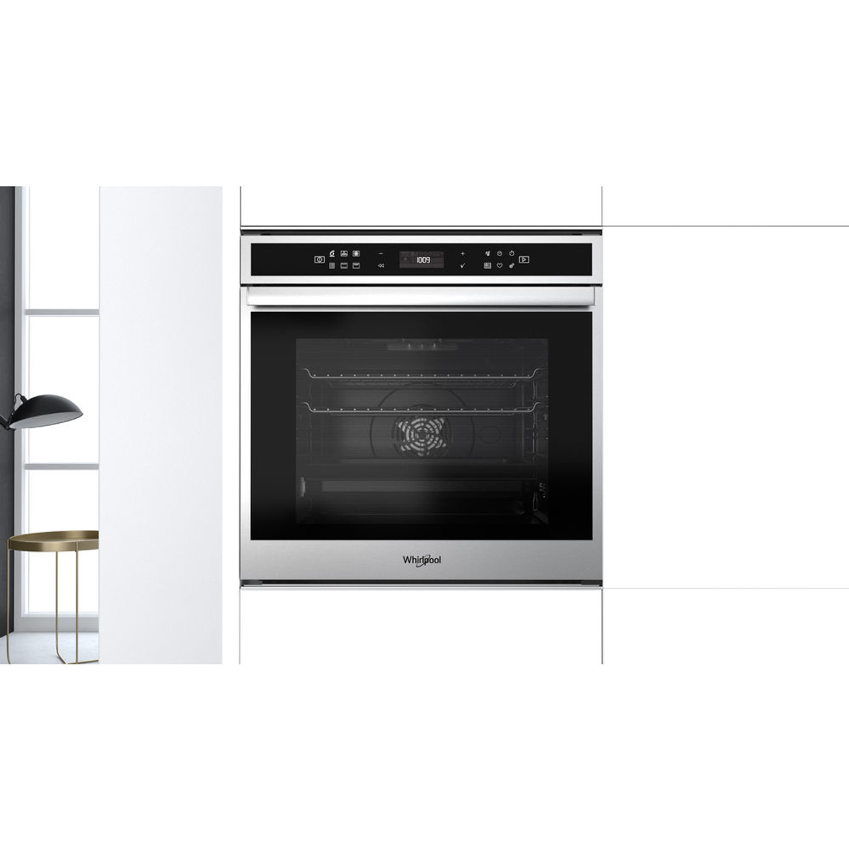 Un horno Whirlpool plateado empotrado en un armario de cocina blanco.