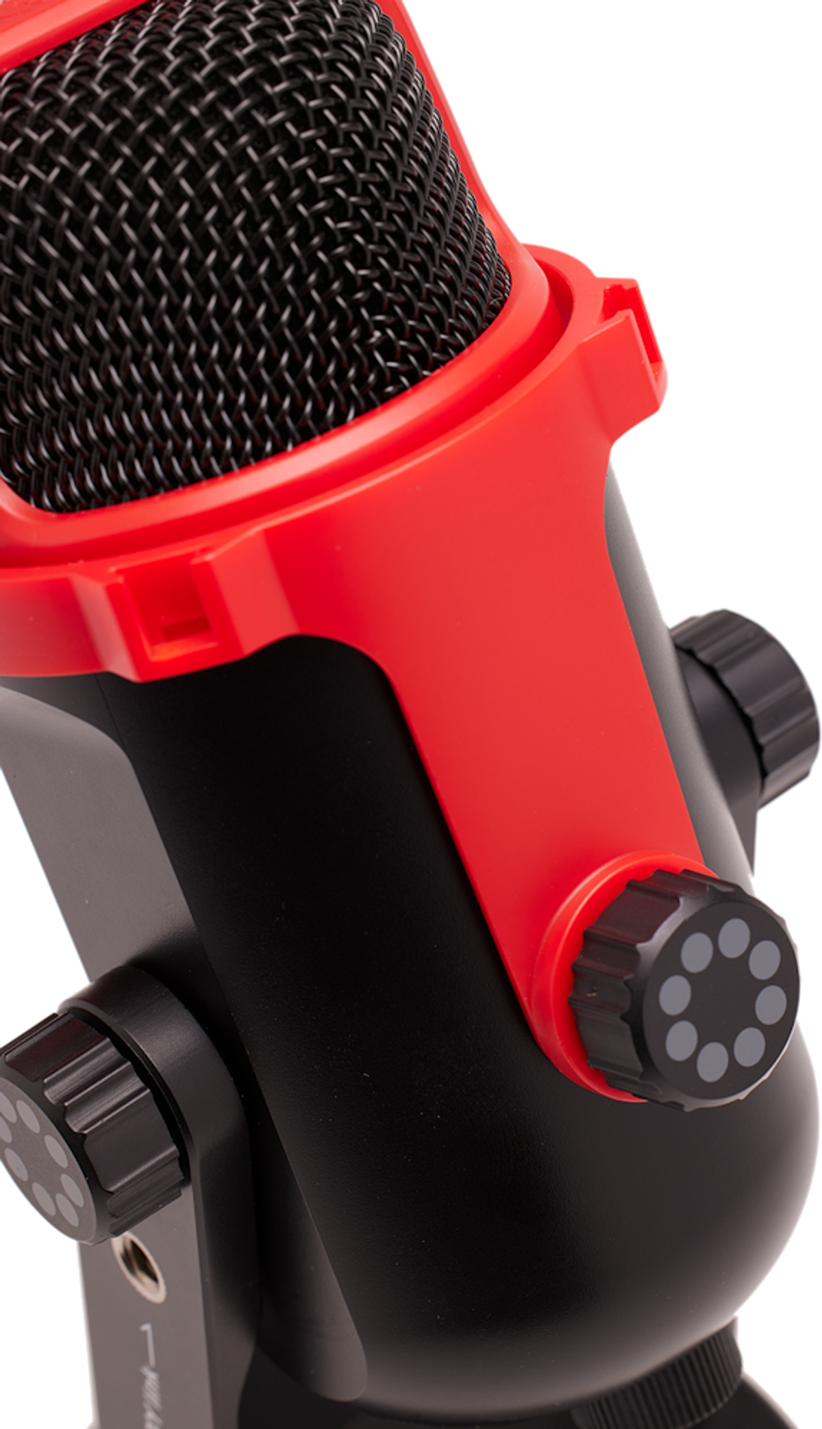 Primer plano de un micrófono rojo y negro con cubierta de malla y perillas de control.
