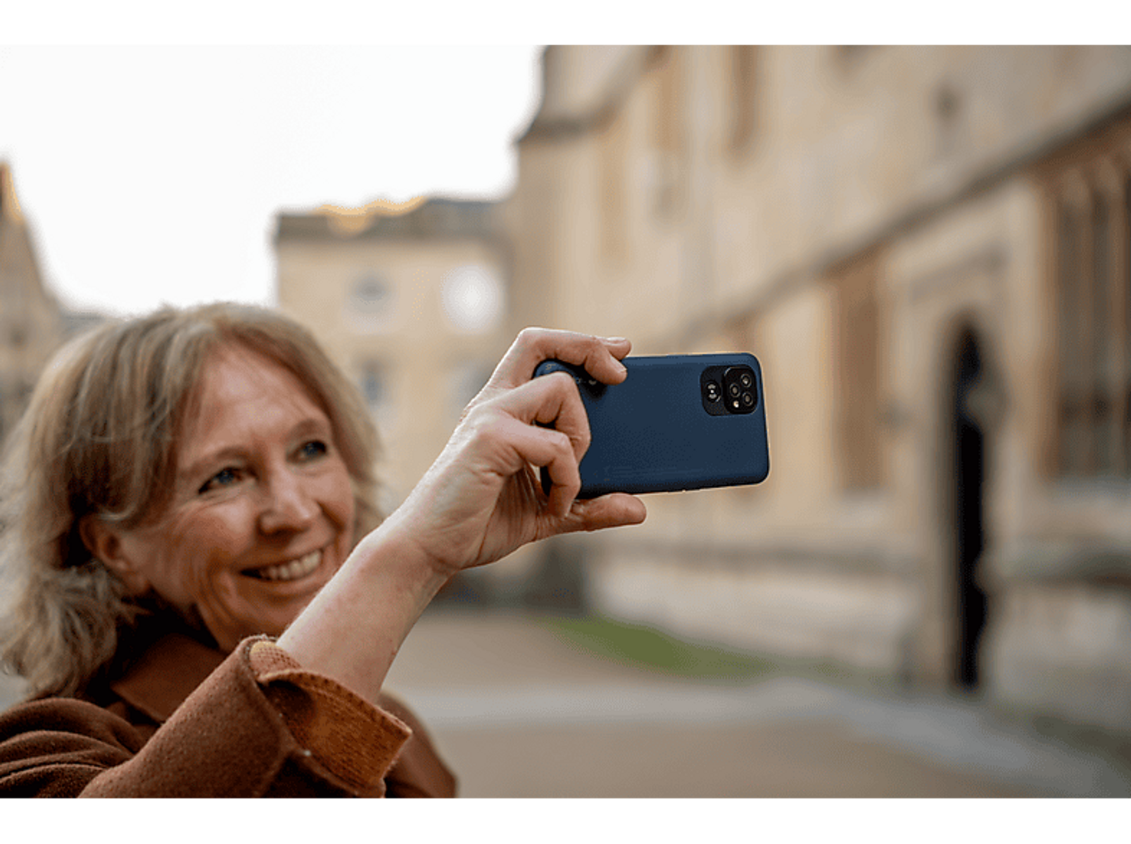 Eine silberne Smartwatch mit hellgrauem Armband, von der Seite betrachtet.