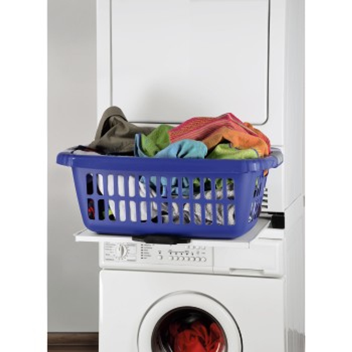 Ein blauer Wäschekorb voller bunter Kleidung steht auf einer weißen Waschmaschine.