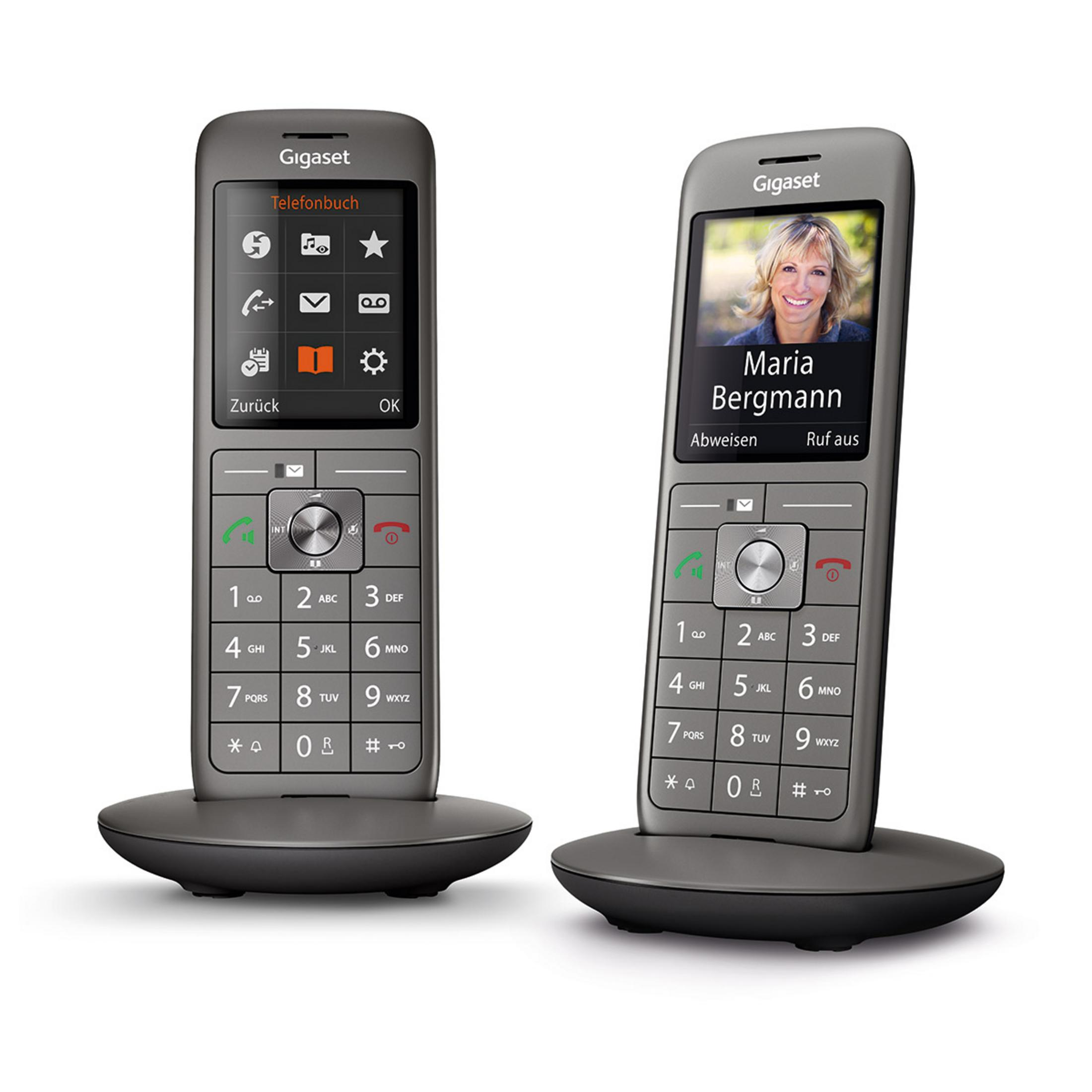 Dos teléfonos inalámbricos Gigaset grises con bases de carga.