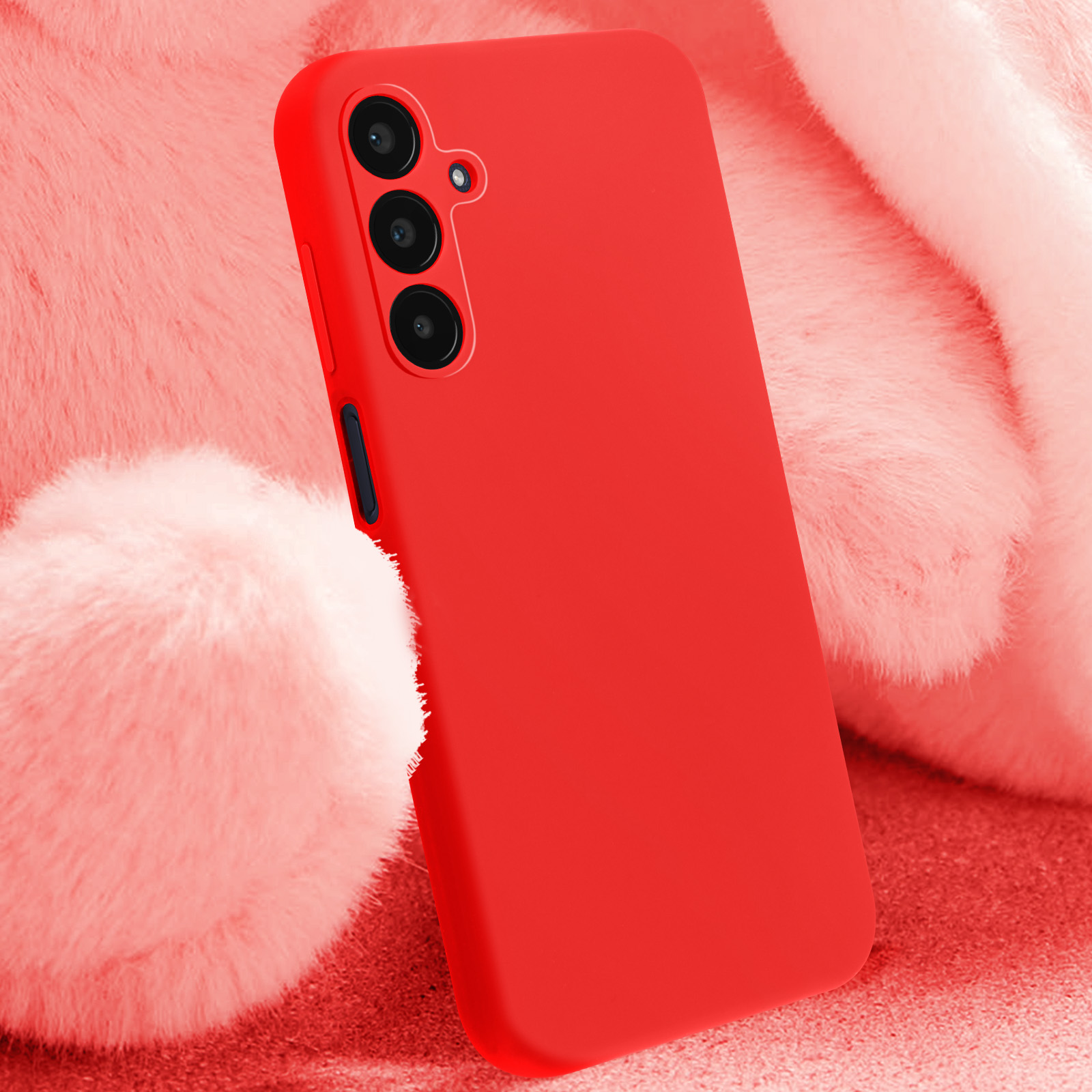 Custodia rossa con tripla fotocamera, su superficie rossa, sfondo rosa sfocato.