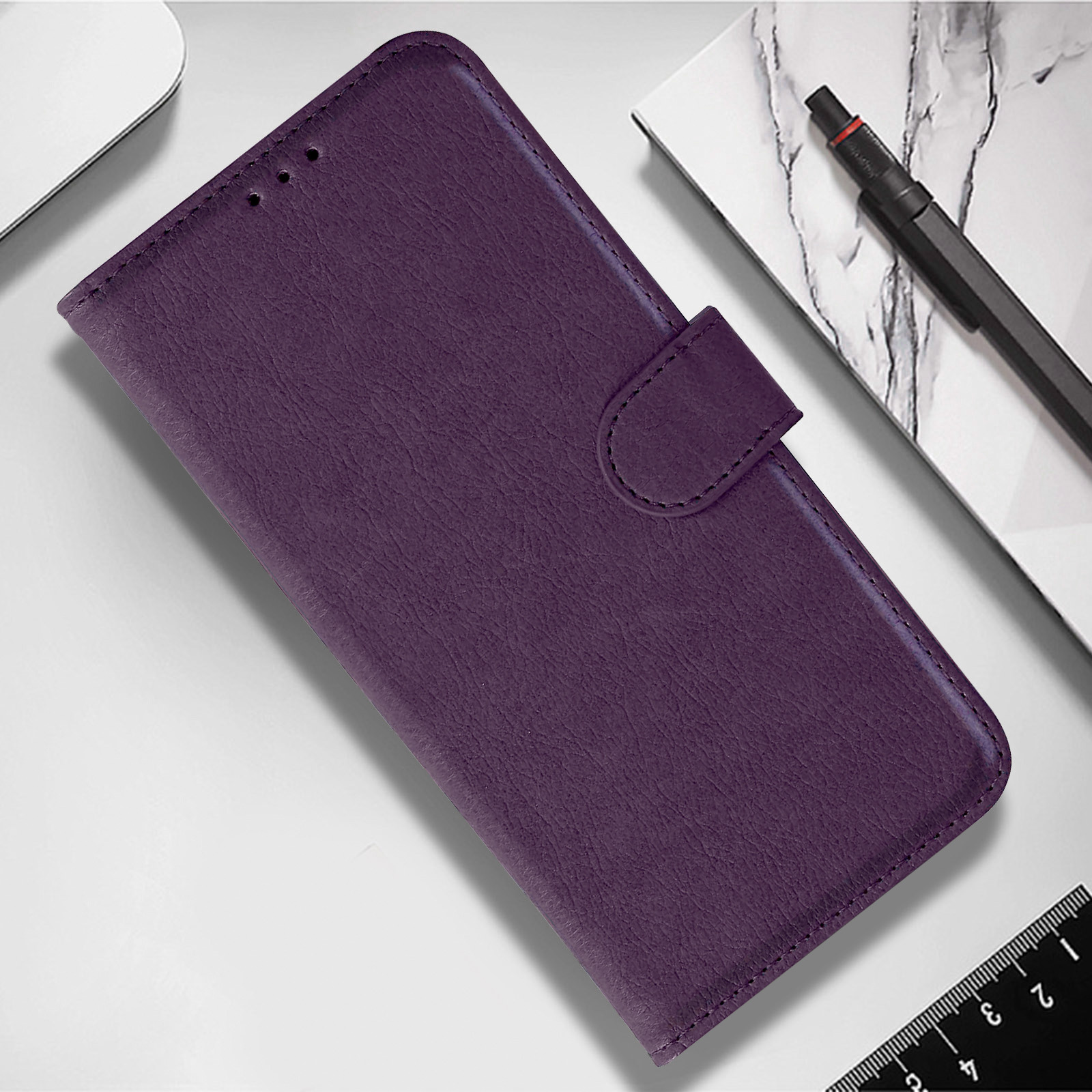 Custodia per telefono in pelle viola con chiusura a bottone e penna.