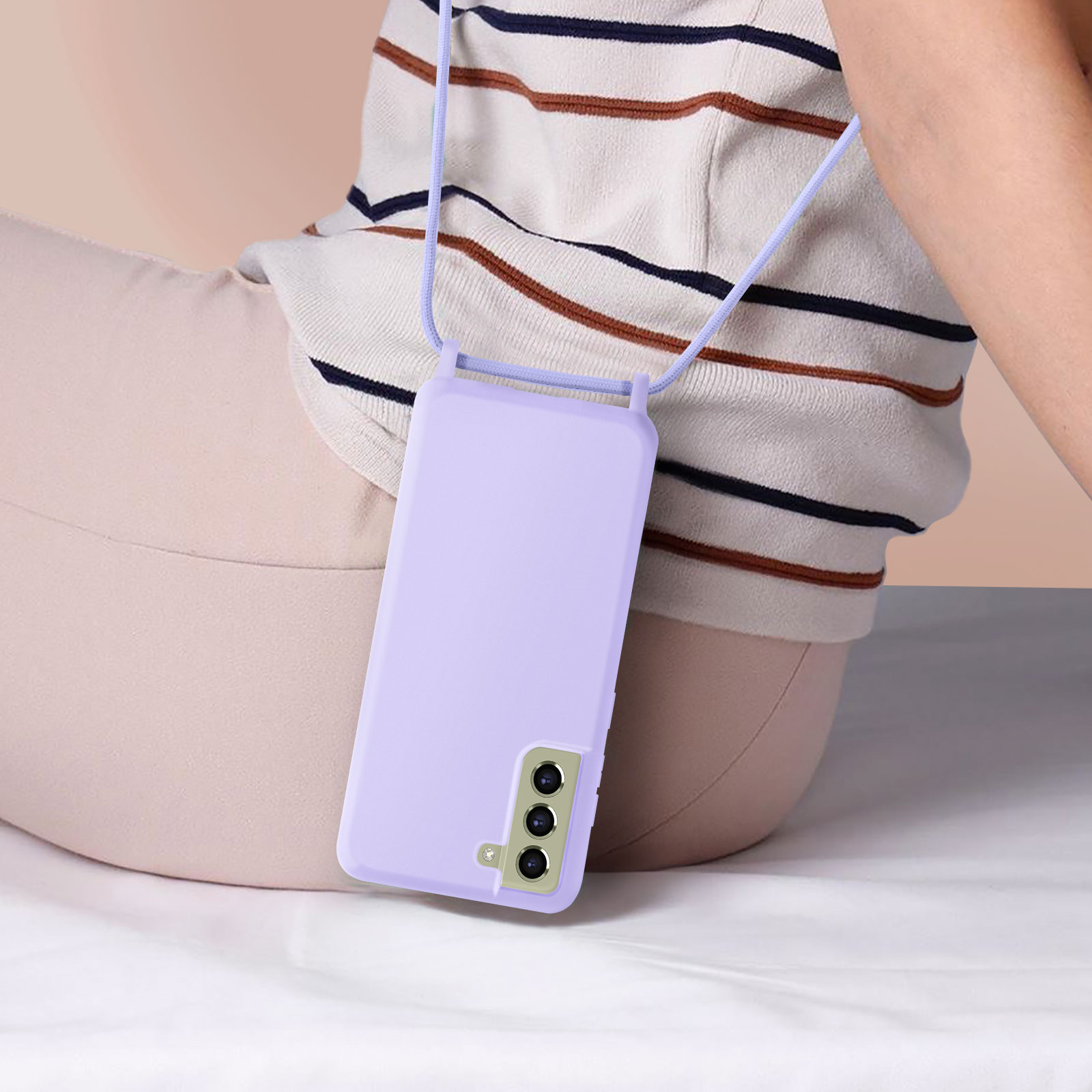 Persona seduta, con custodia viola per telefono su cordino. Visibili anche pantaloni beige e camicia a righe.