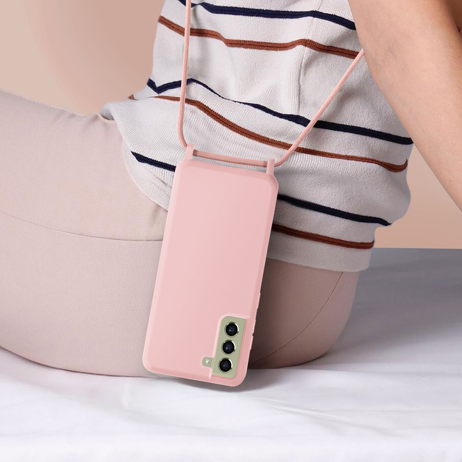 Persona con custodia rosa con cordino. Primo piano del telefono e del cordino.