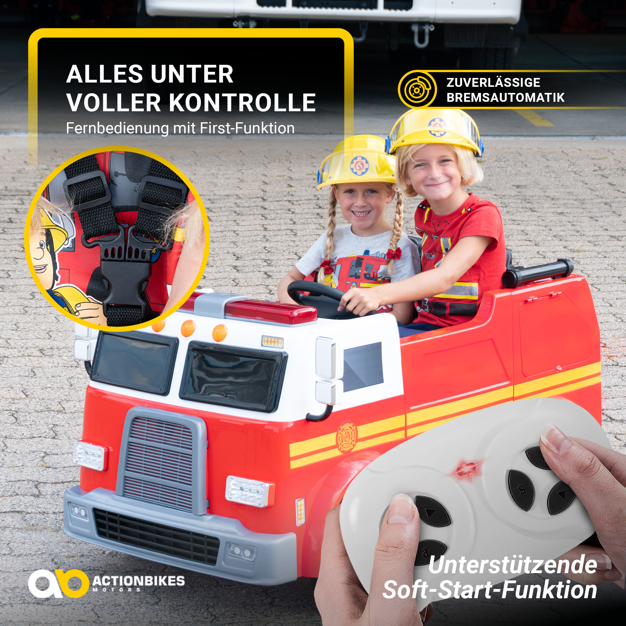 Zwei Kinder in einem roten Spielzeug-Feuerwehrauto. Die Hand eines Erwachsenen hält eine Fernbedienung.