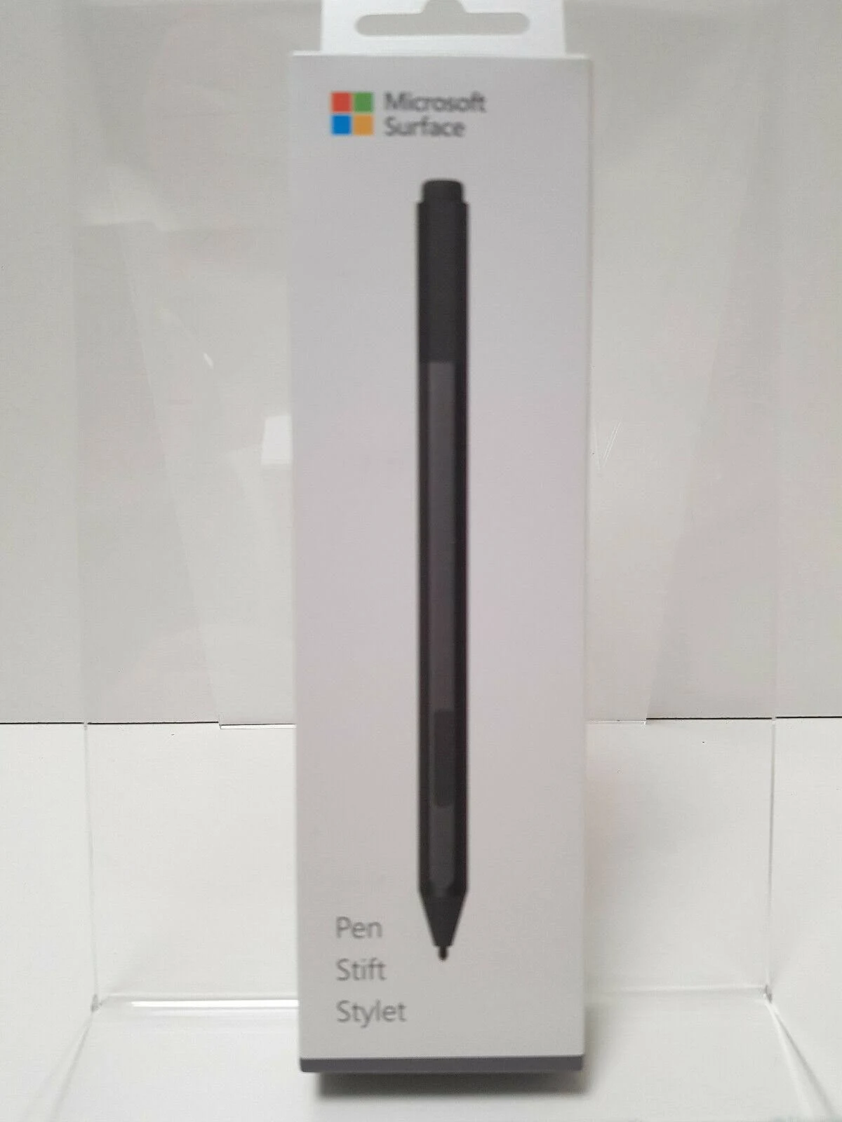Pióro Microsoft Surface w białym pudełku. Pióro jest czarne z szarą końcówką.