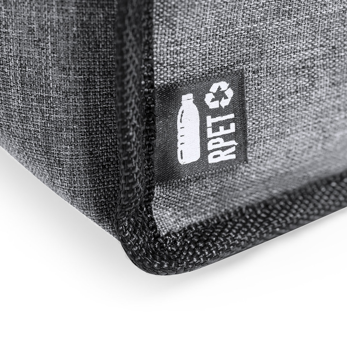 Primer plano de la esquina de una bolsa gris, con una etiqueta que muestra el texto 'rPET'.