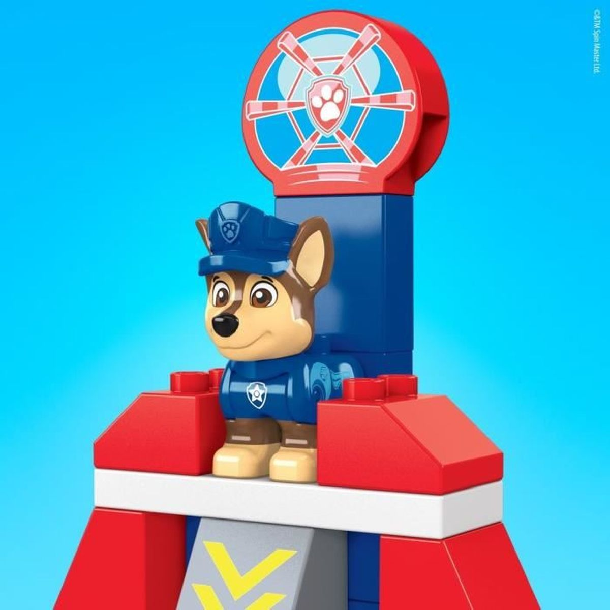 Un set di giocattoli di Paw Patrol. Chase, il cane poliziotto, è in piedi su una struttura di blocchi di costruzione.