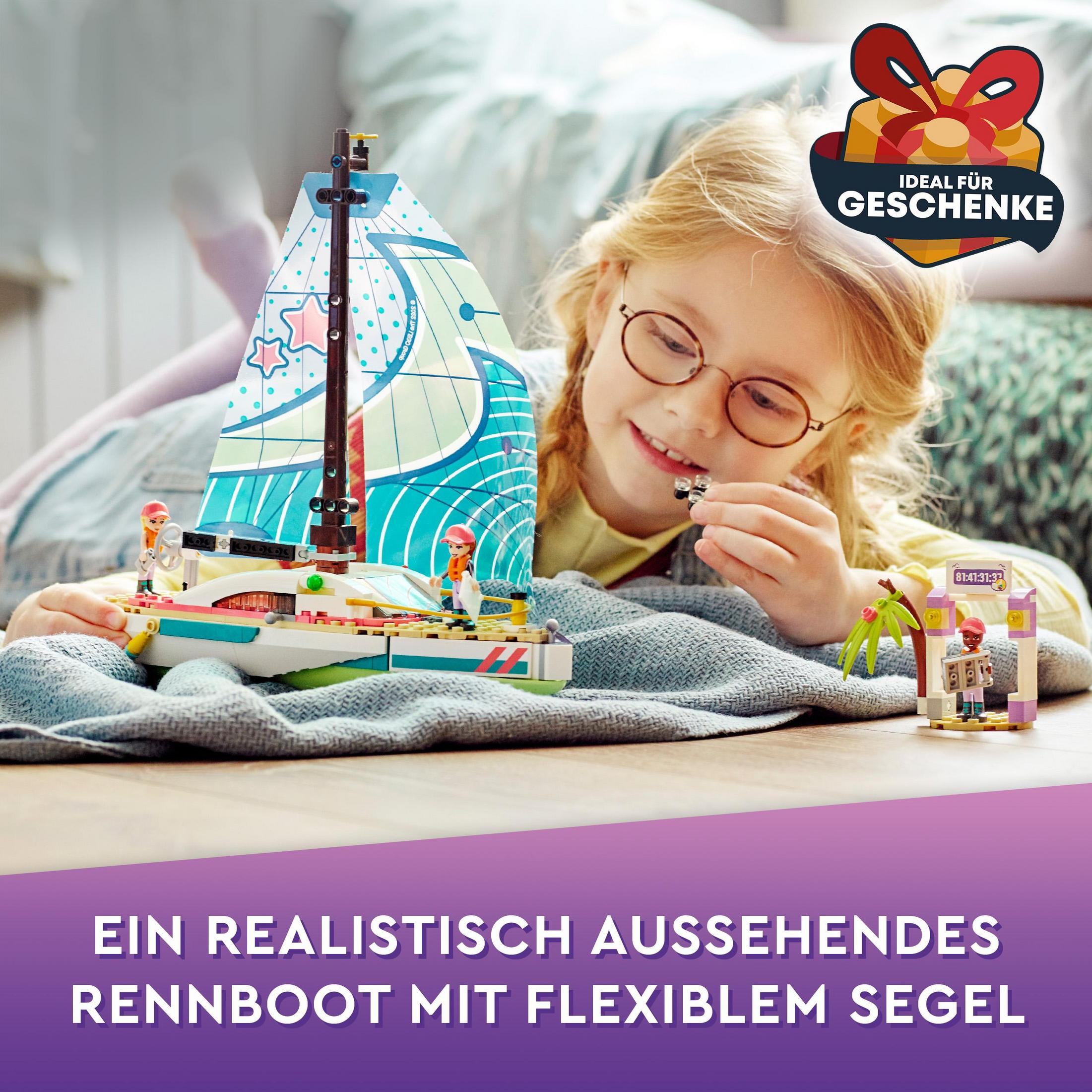 Een meisje speelt met een speelgoedzeilboot. Er is een LEGO-set van een boot en een klein eiland.