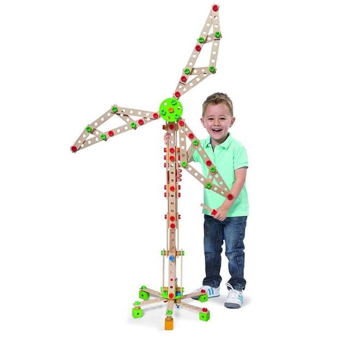 Chłopiec budujący drewniany wiatrak, uśmiechnięty, białe tło.