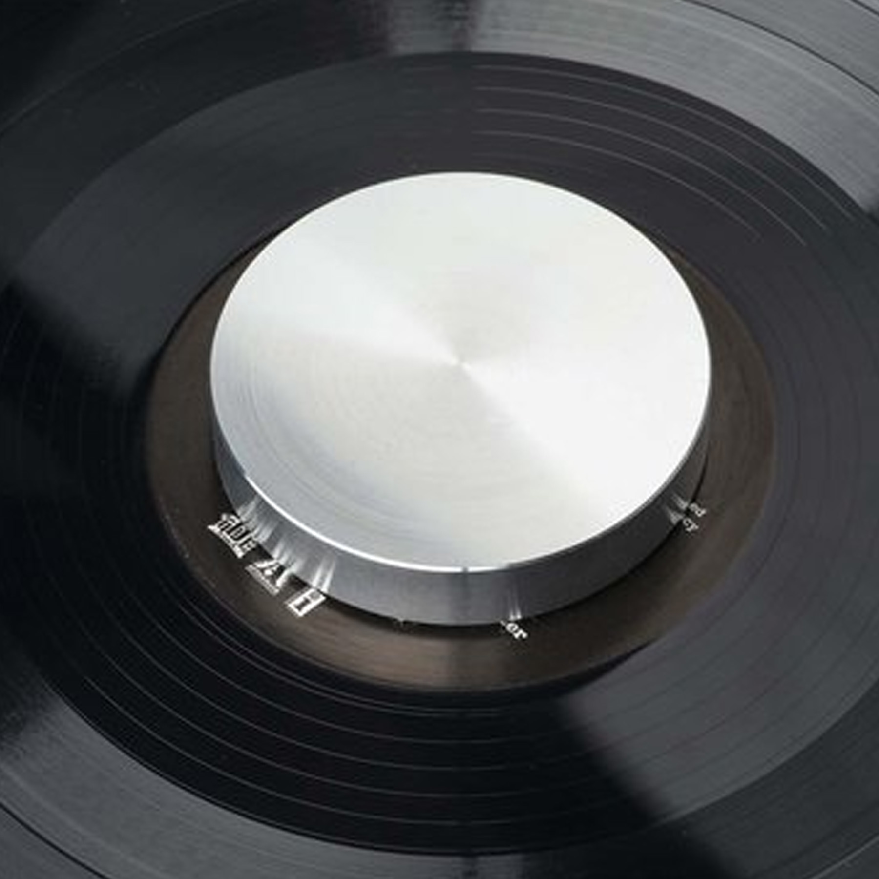 Gramofon ze srebrną częścią centralną i czarną płytą winylową.