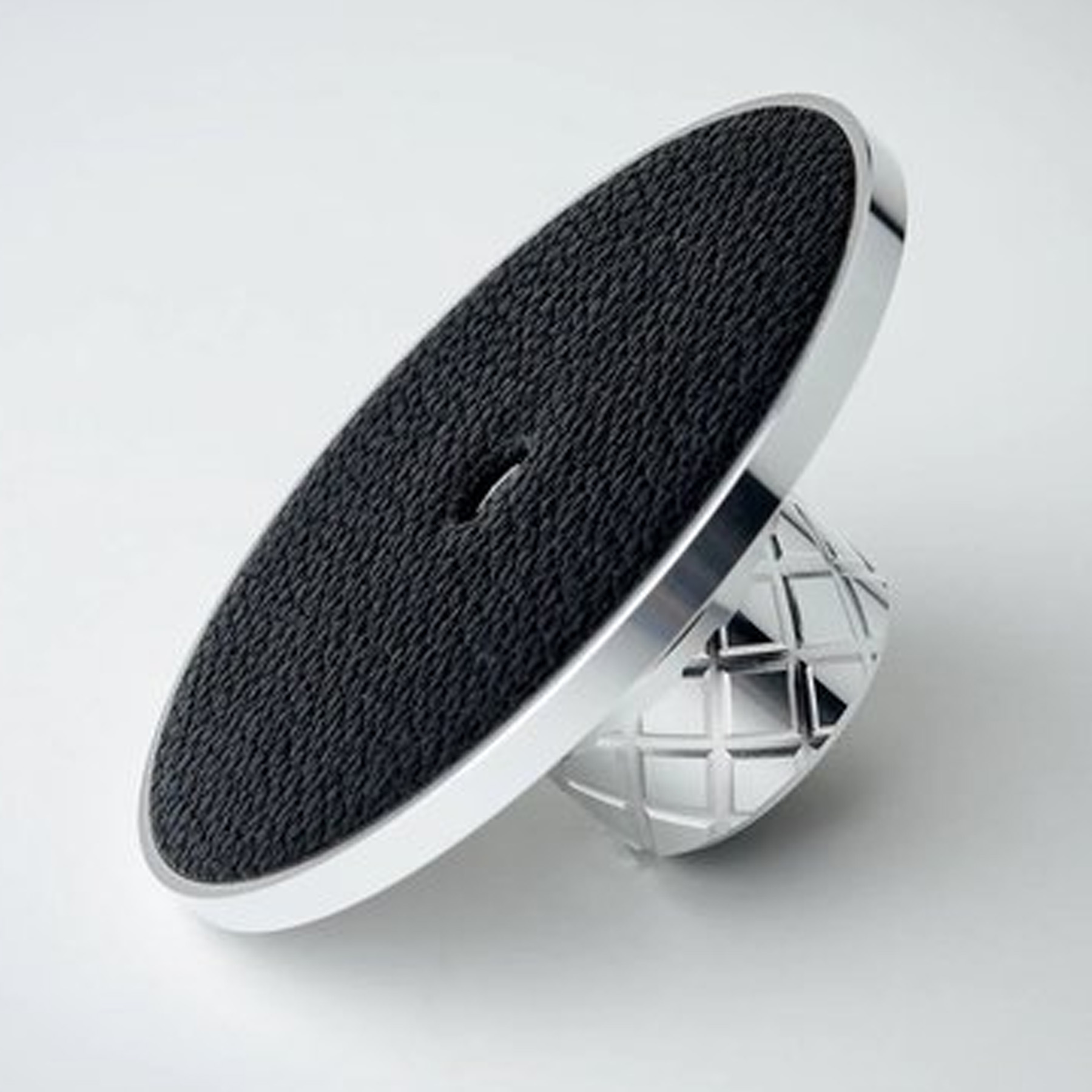 A silver phone stand with a textured black surface. Diamond-patterned base.