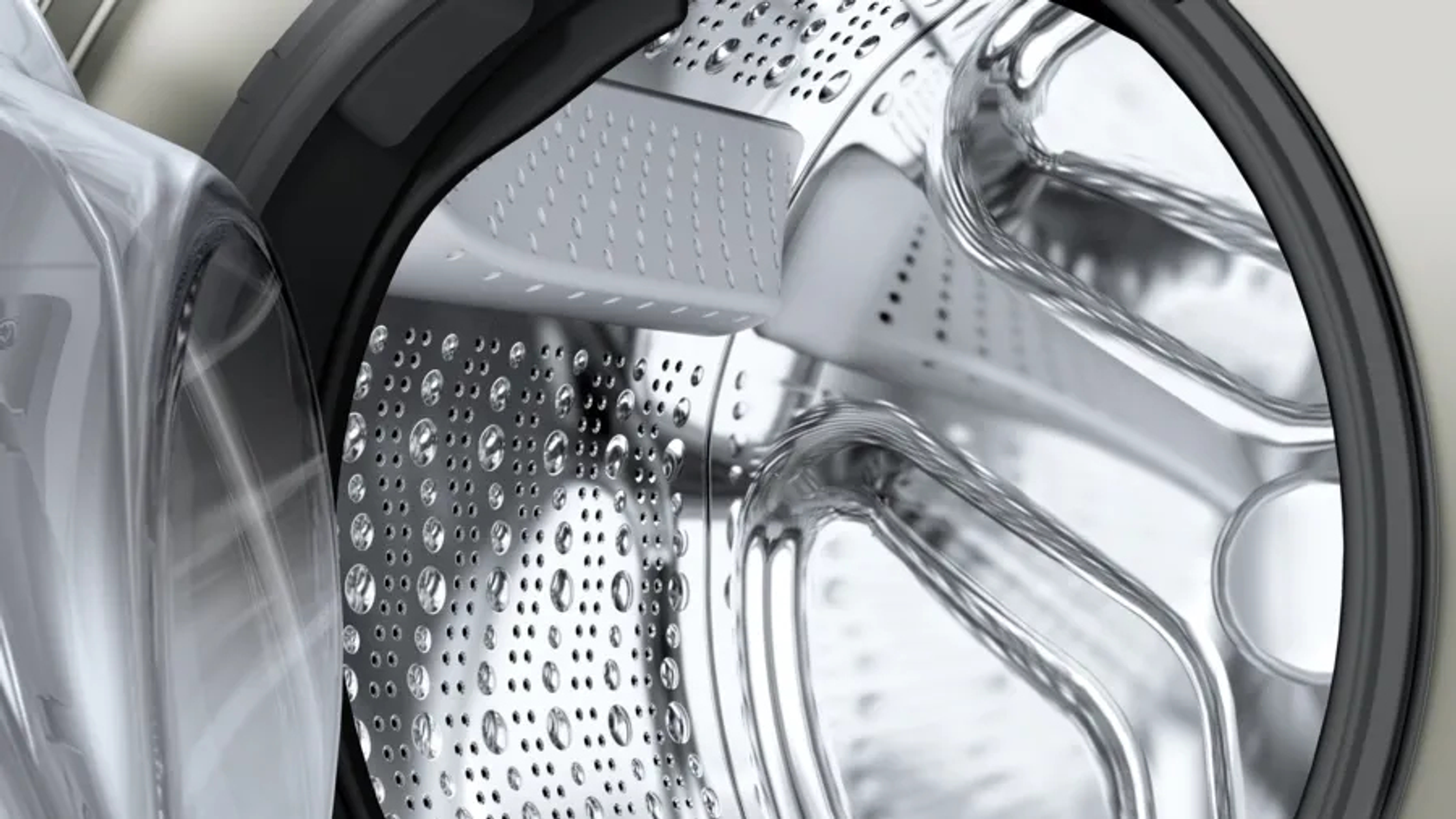 Primer plano del interior del tambor de una lavadora con gotas de agua.