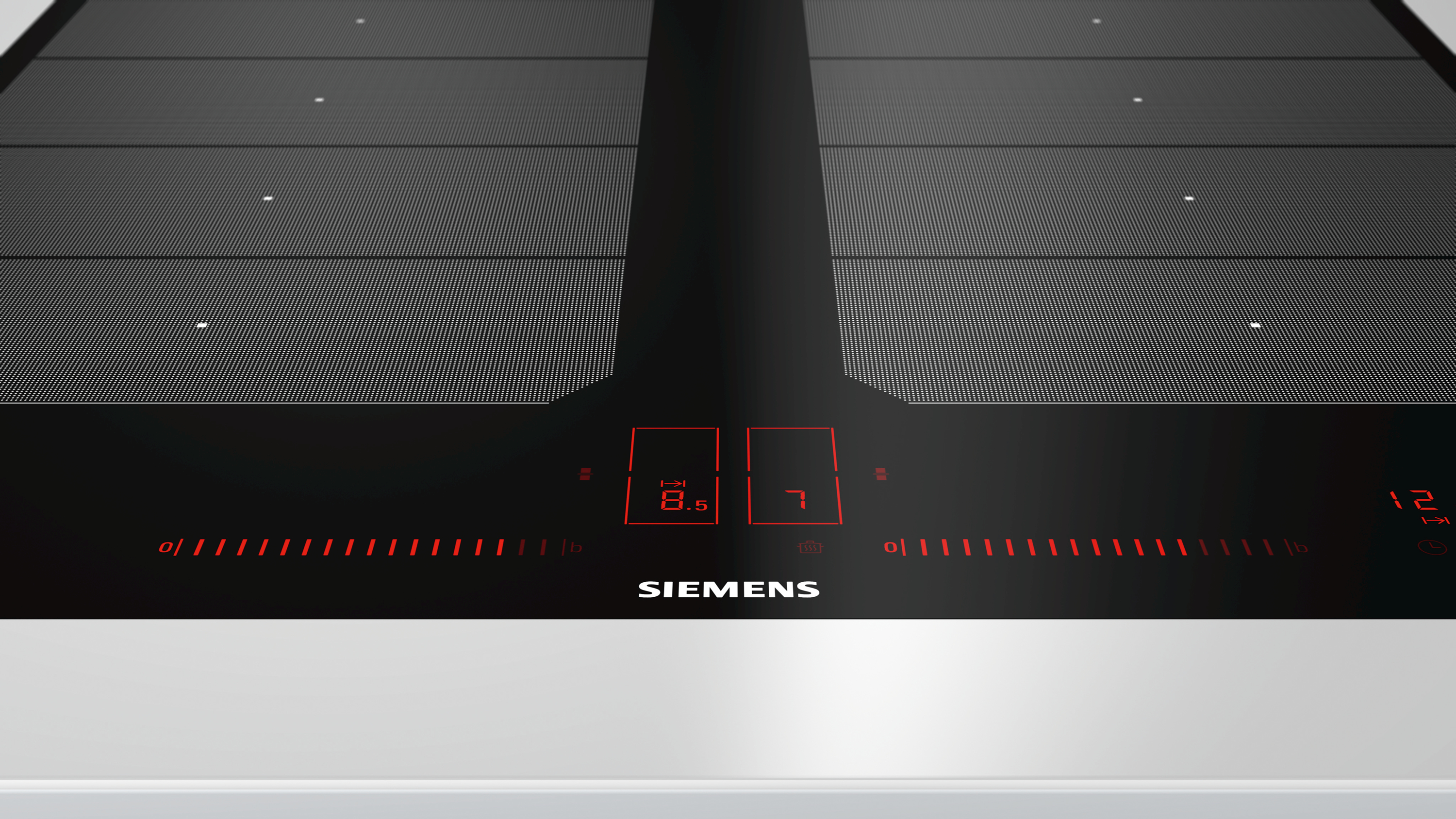 Zbliżenie czarnej płyty grzewczej z czerwonymi światłami. Wyświetla liczby 8,5 i 7.