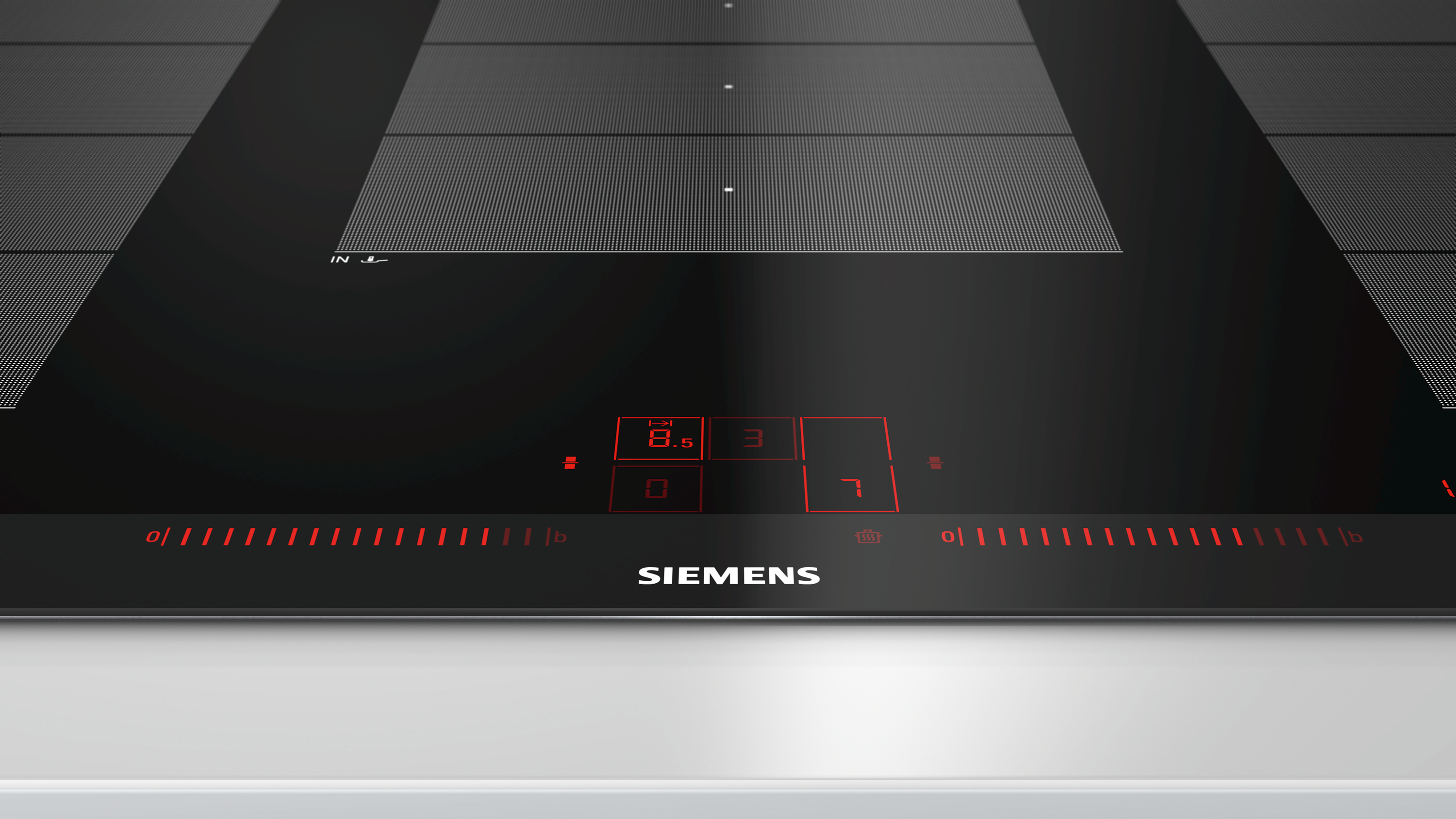 Zwarte Siemens inductiekookplaat. Rood display. Zwart glazen oppervlak. Wit aanrecht.