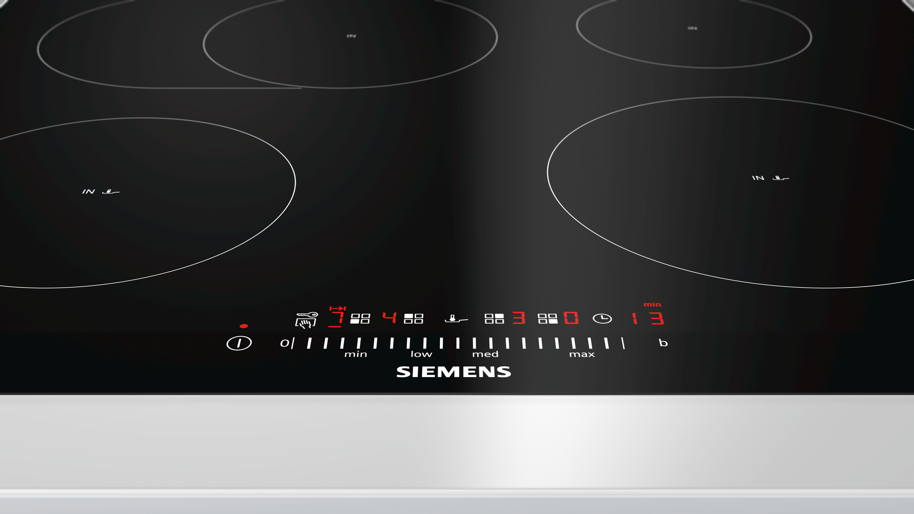 Piano cottura a induzione nero con quattro zone di cottura e display digitale, con il logo Siemens.