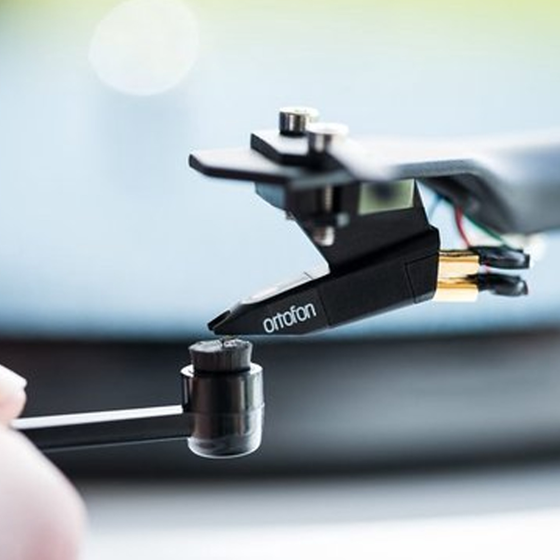 Zbliżenie czarnej i srebrnej igły gramofonowej, z marką 'ortofon'.